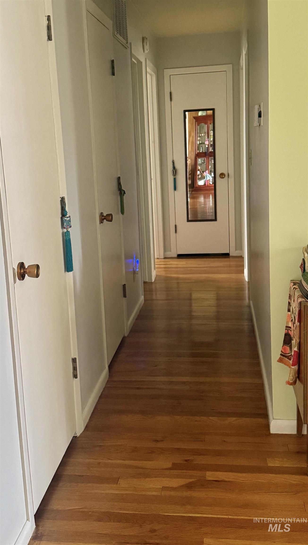 Corridor with dark wood-style floors and baseboards