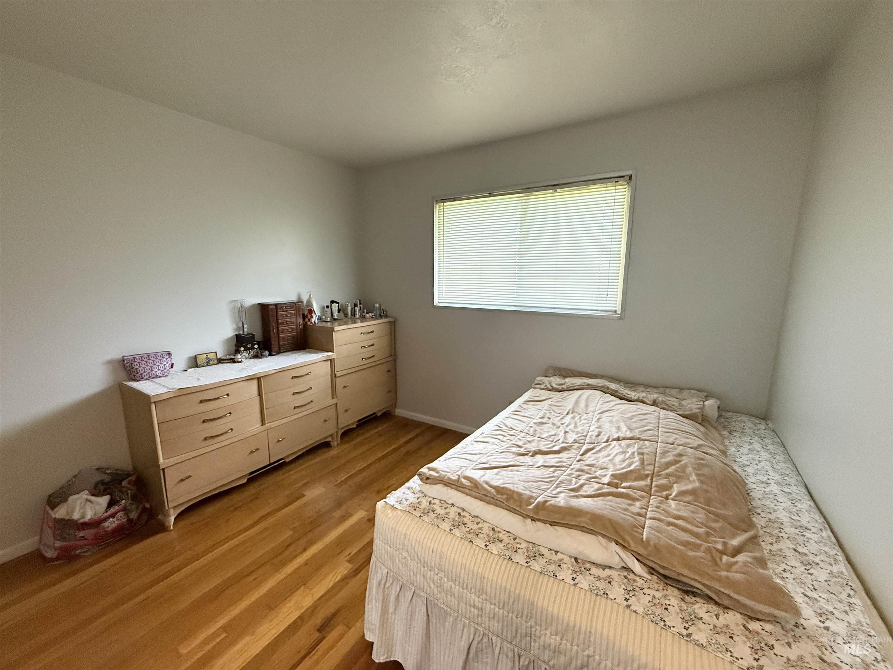 Bedroom with light wood-style flooring and baseboards