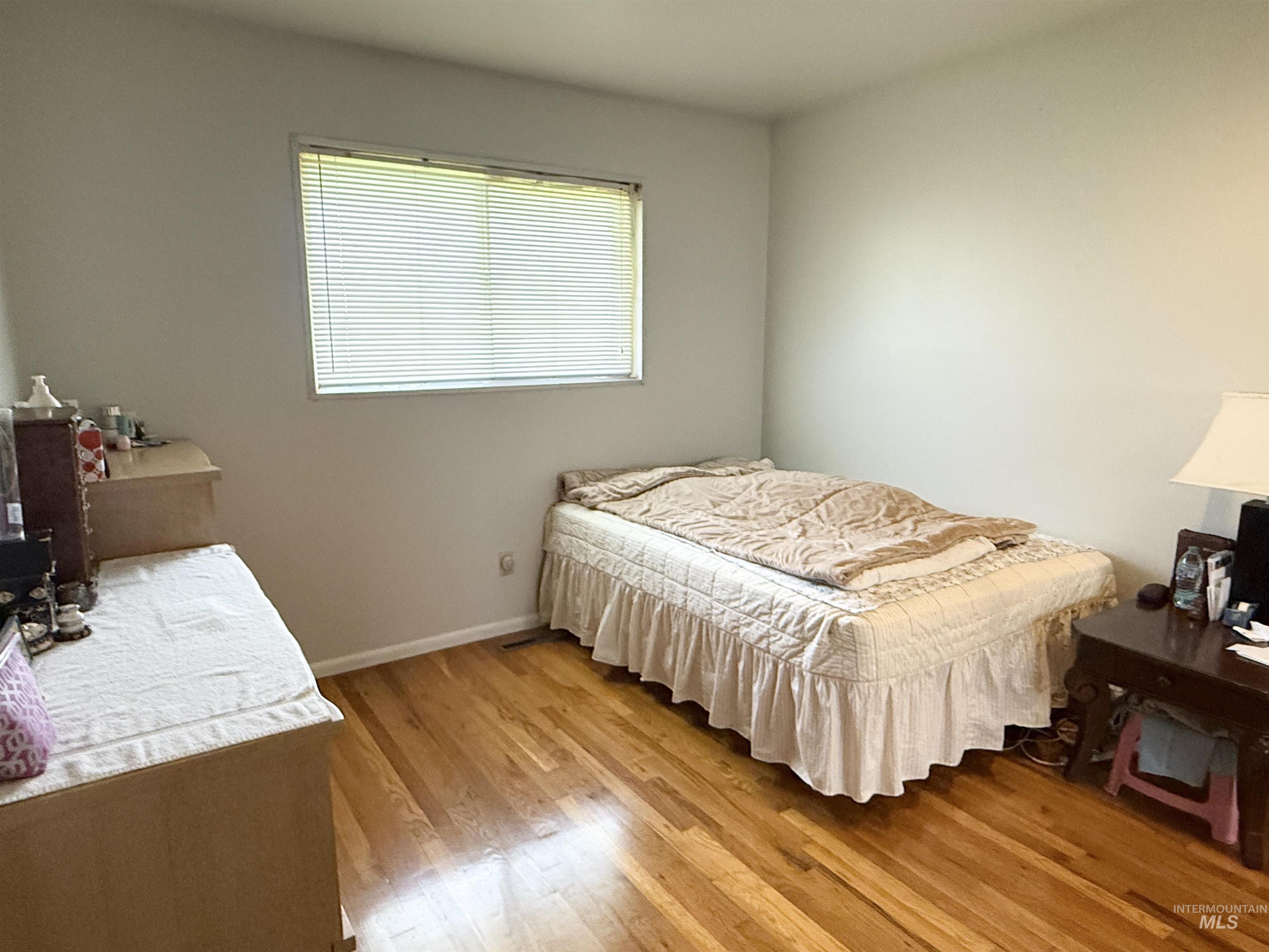 Bedroom with light wood-style flooring and baseboards