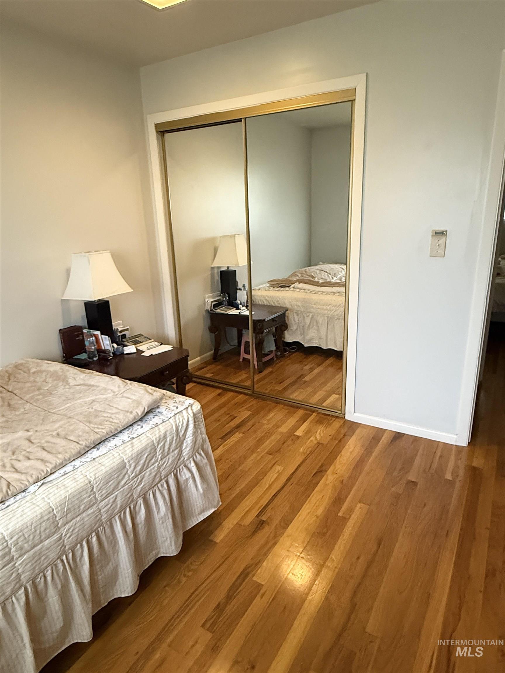 Bedroom with light wood finished floors and a closet