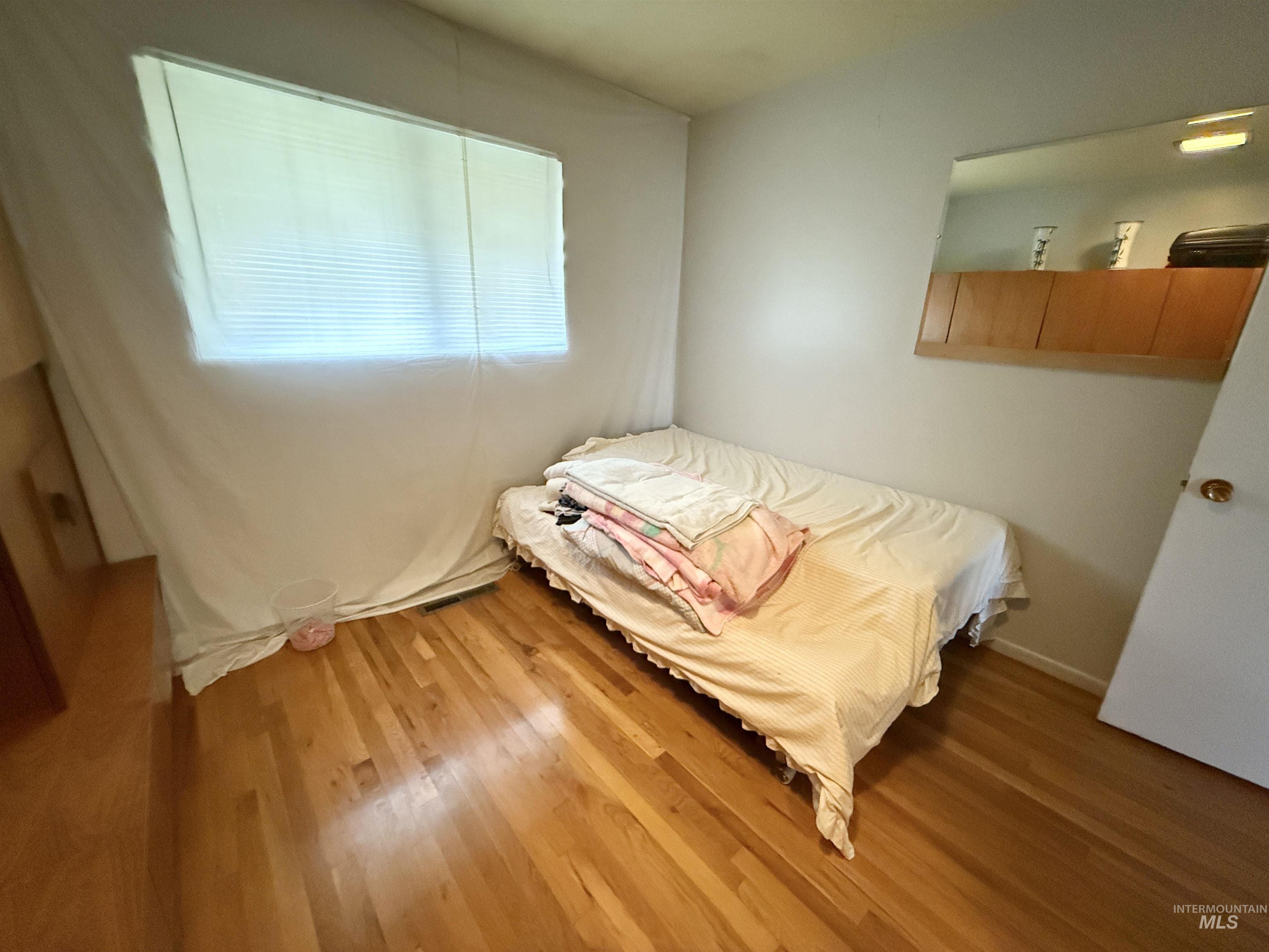 Bedroom featuring light wood-type flooring and baseboards