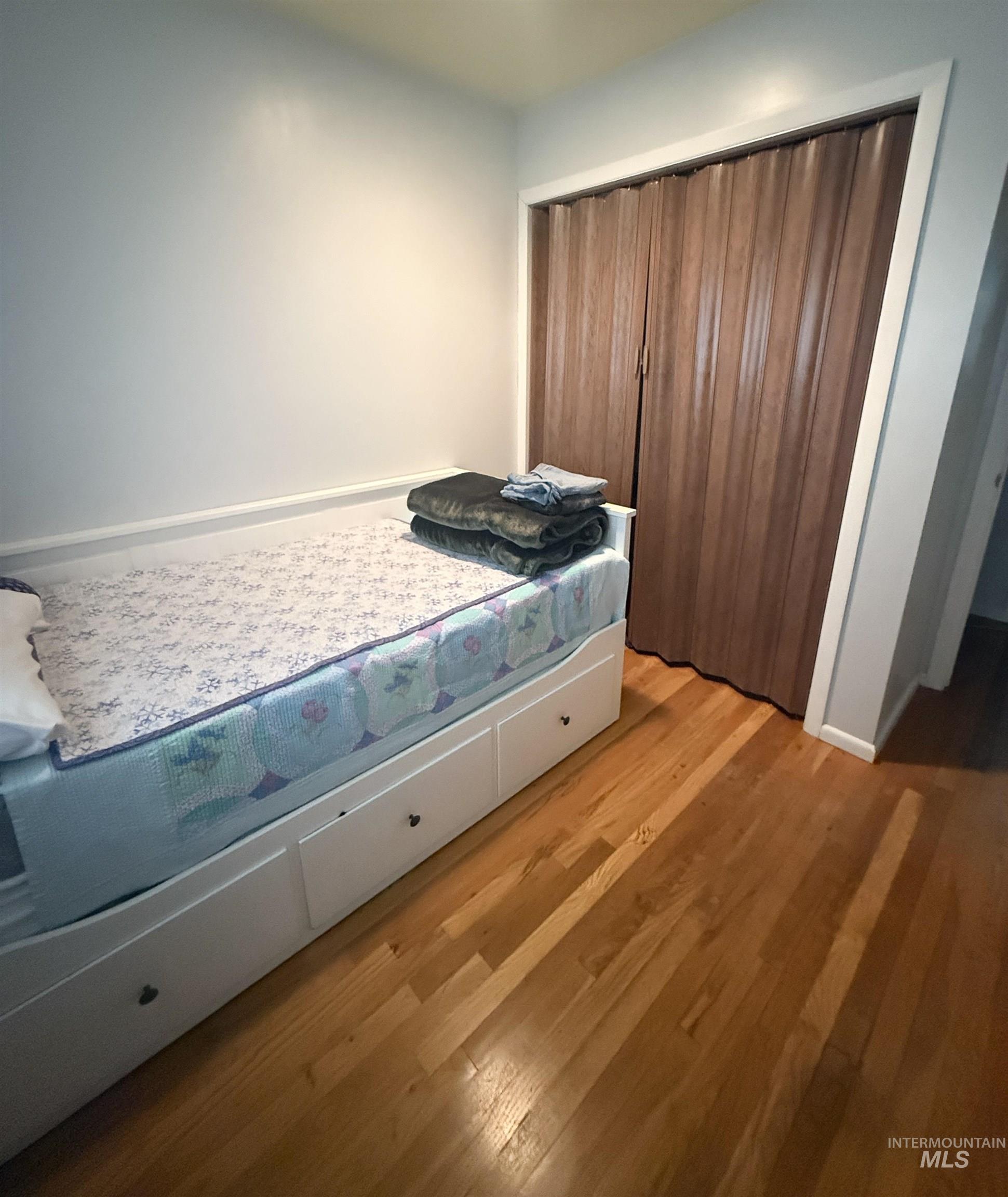 Bedroom with light wood-type flooring and a closet