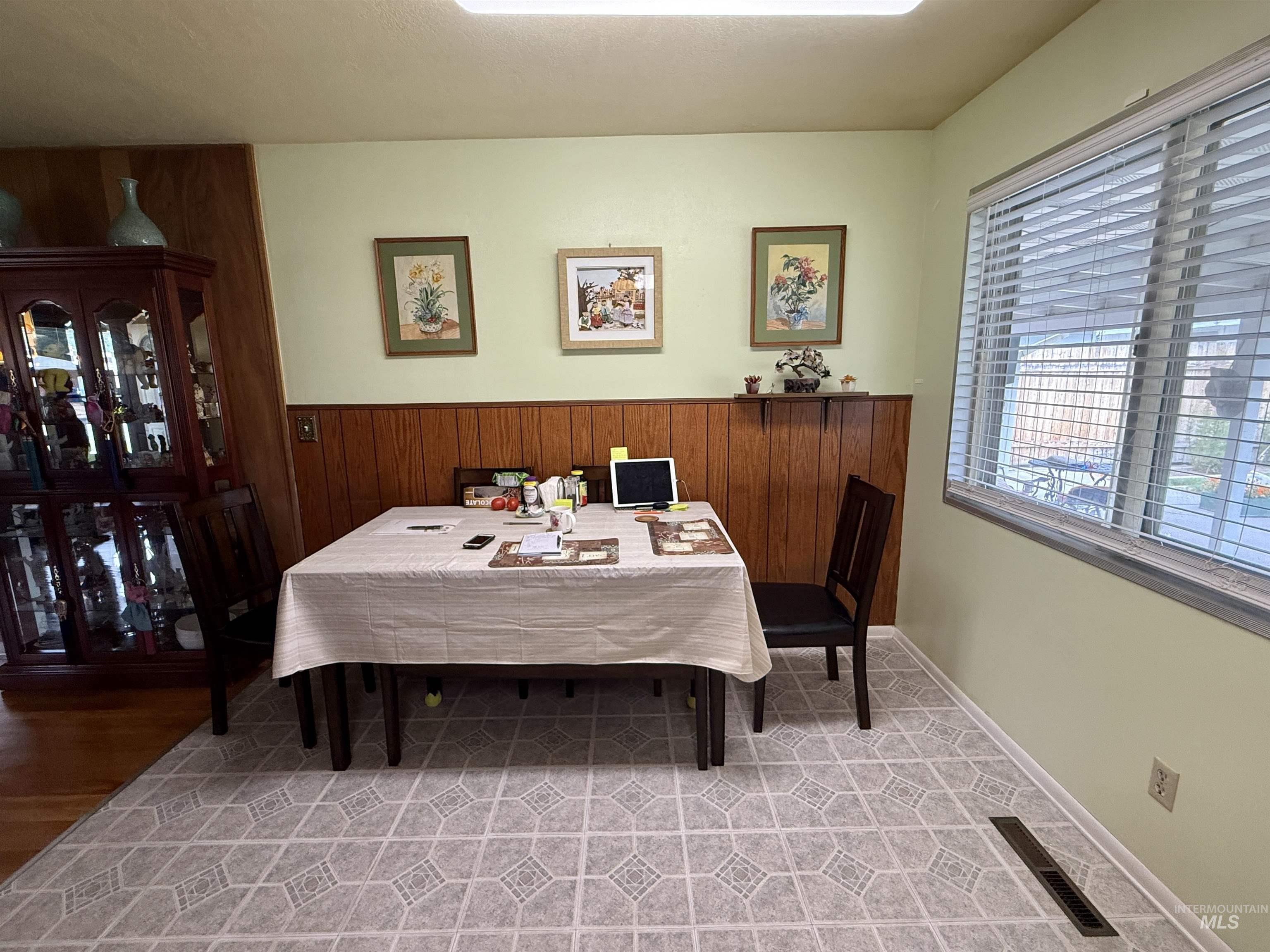 Dining room featuring wooden walls and light tile patterned floors