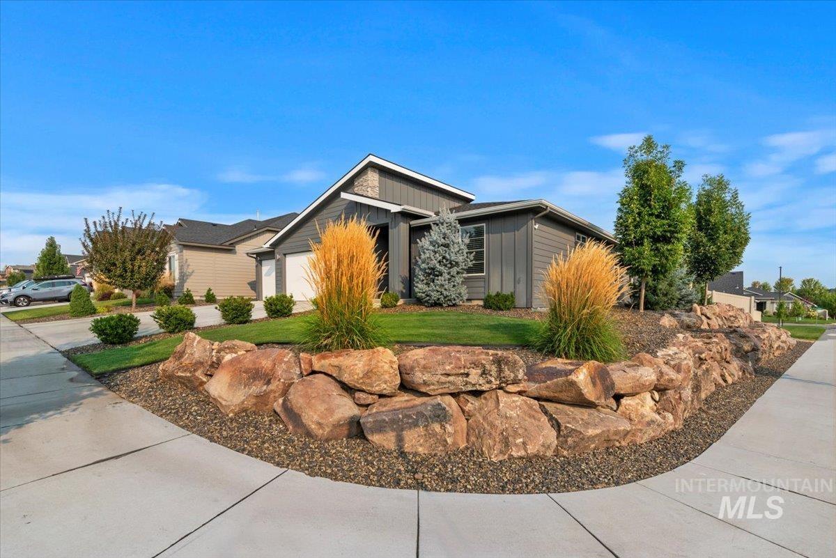 View of front of property with board and batten siding, a garage, and driveway