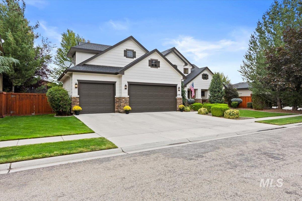 Craftsman inspired home with concrete driveway, stone siding, and a shingled roof