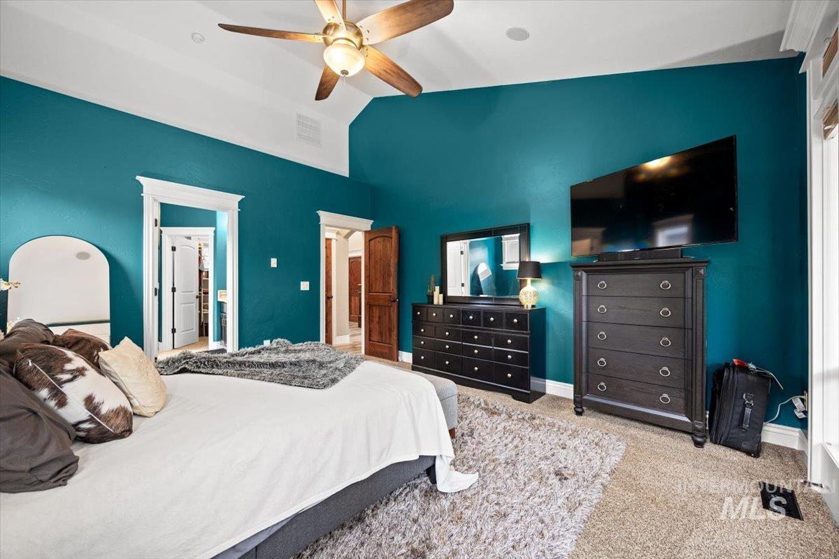 Bedroom with carpet, lofted ceiling, and a ceiling fan