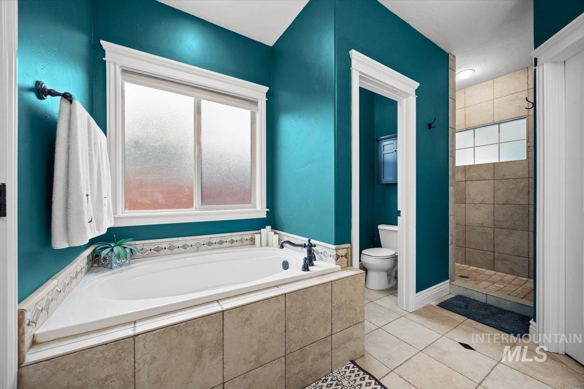 Bathroom with a stall shower, a bath, and light tile patterned floors
