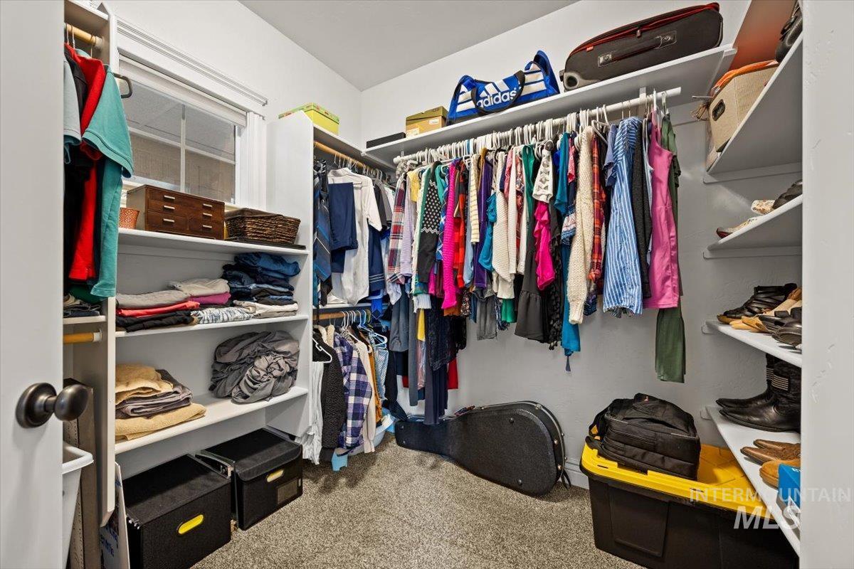 Spacious closet with light colored carpet in master bedroom