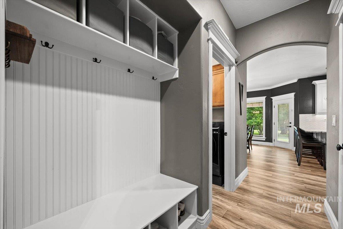 Mudroom with light wood-style floors and arched walkways