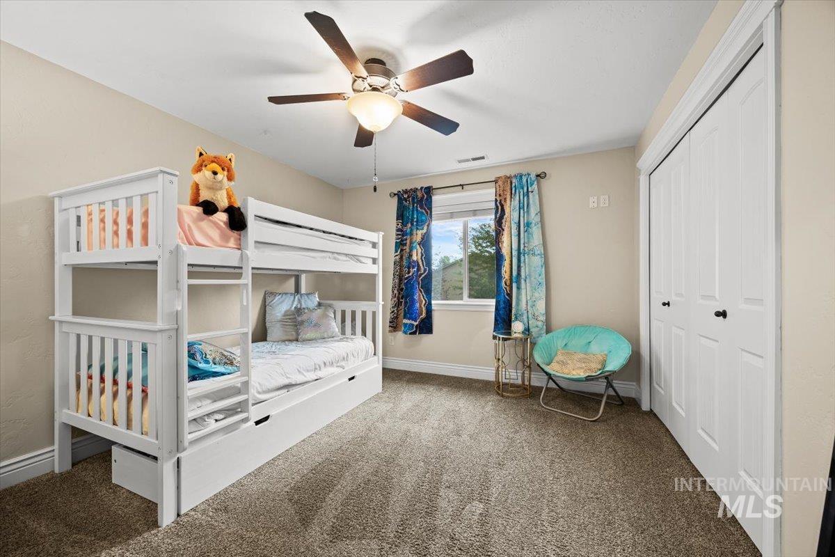 Bedroom with carpet, a closet, and a ceiling fan