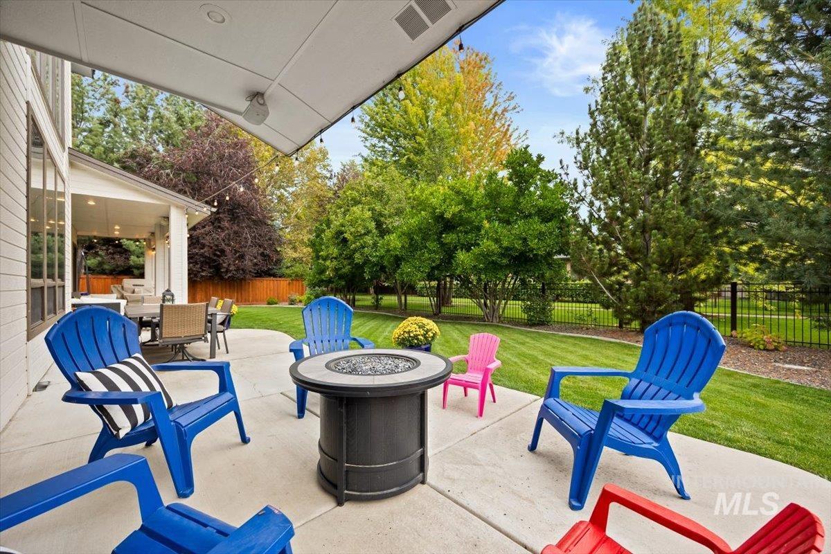 Fenced backyard featuring a fire pit and a patio