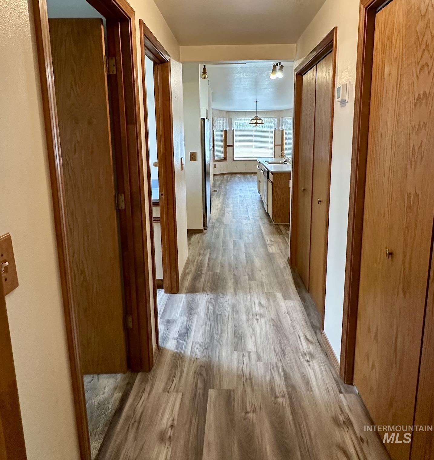 Hallway with light wood-style floors and baseboards