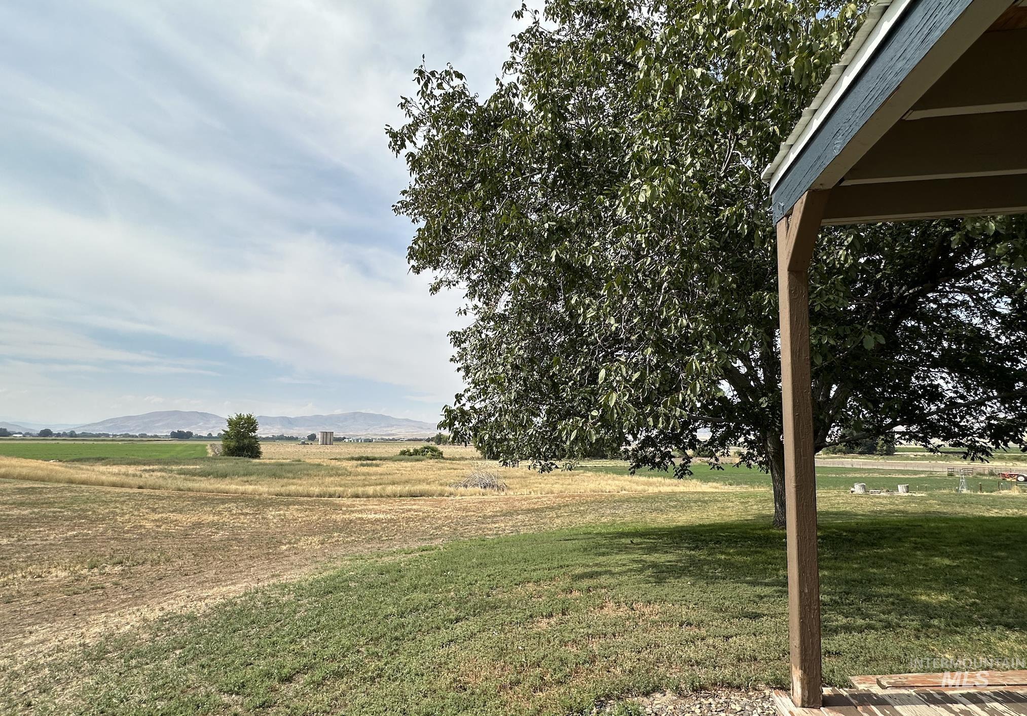 View of grassy yard featuring a view of rural / pastoral area and a mountain view