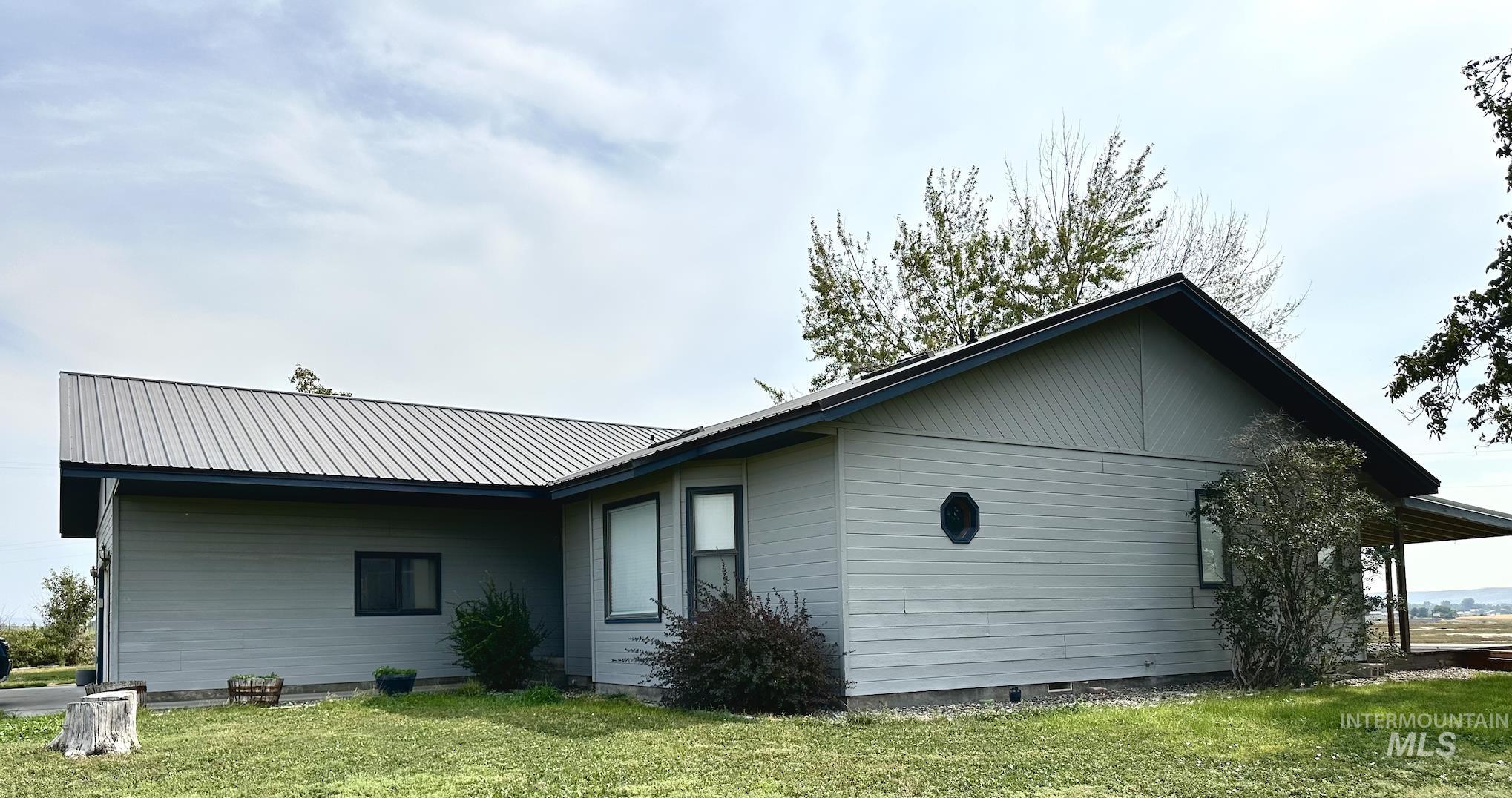 Back of house featuring a yard, a metal roof, and crawl space