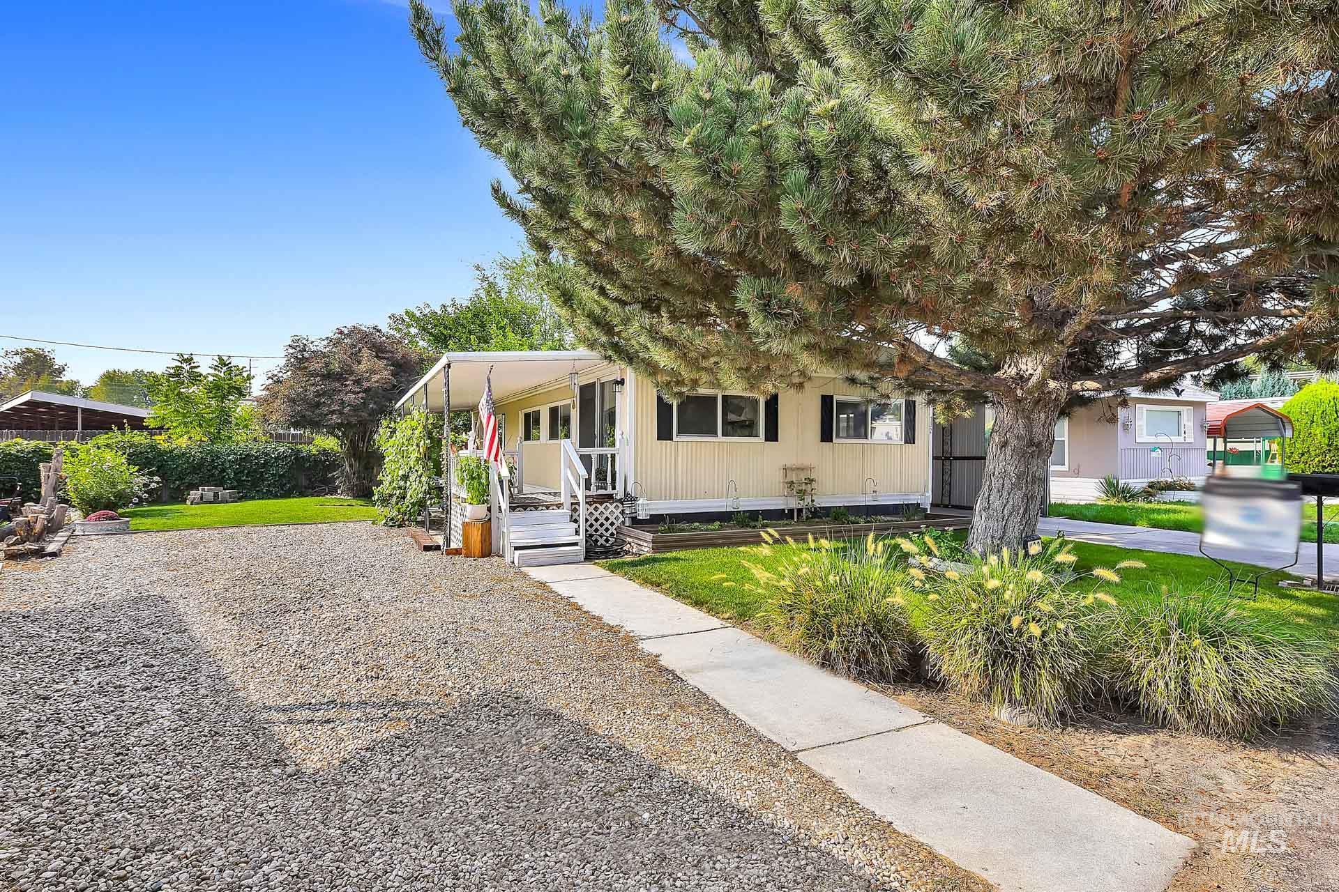 Manufactured / mobile home featuring covered porch and a front lawn