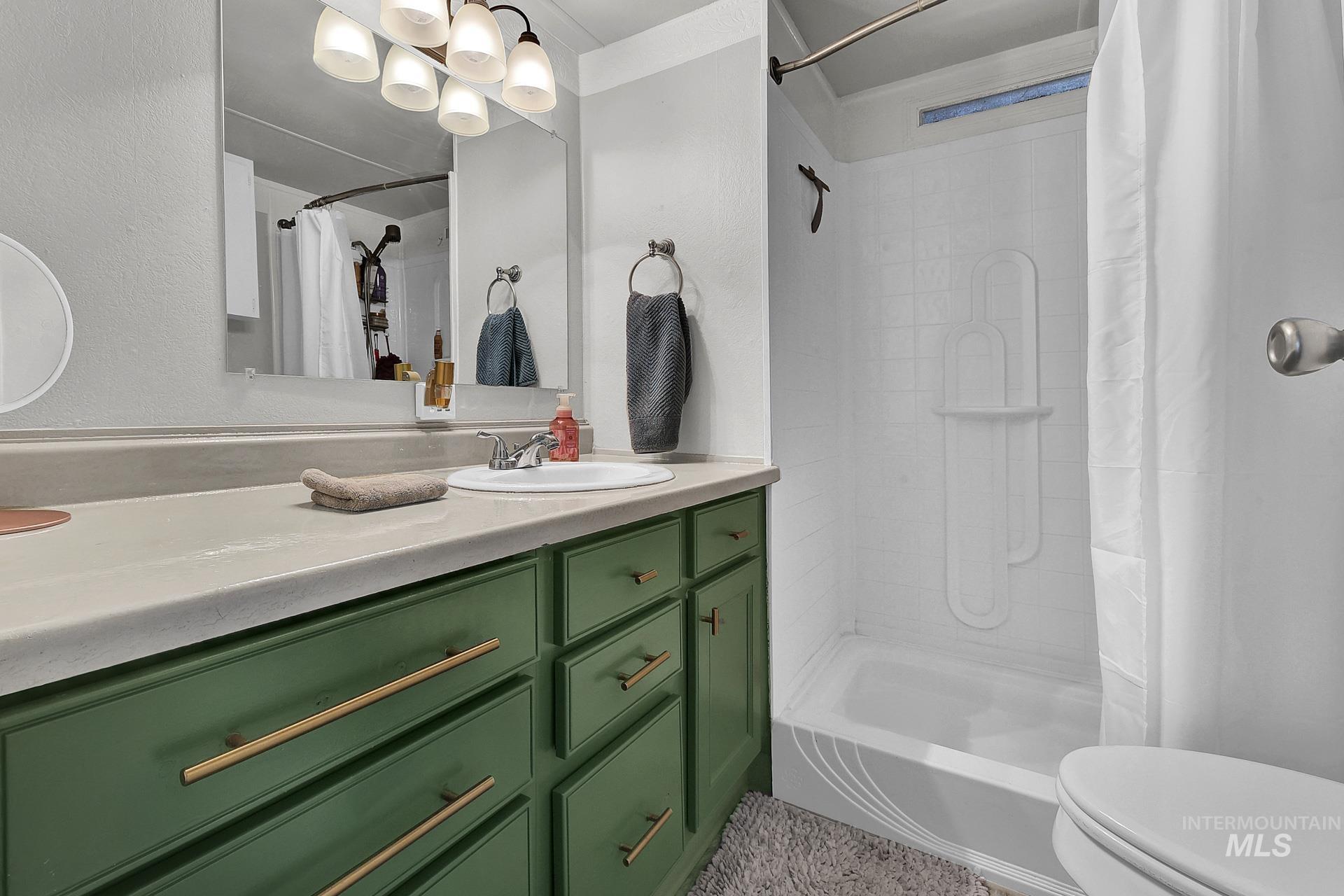 Full bath featuring vanity and curtained shower