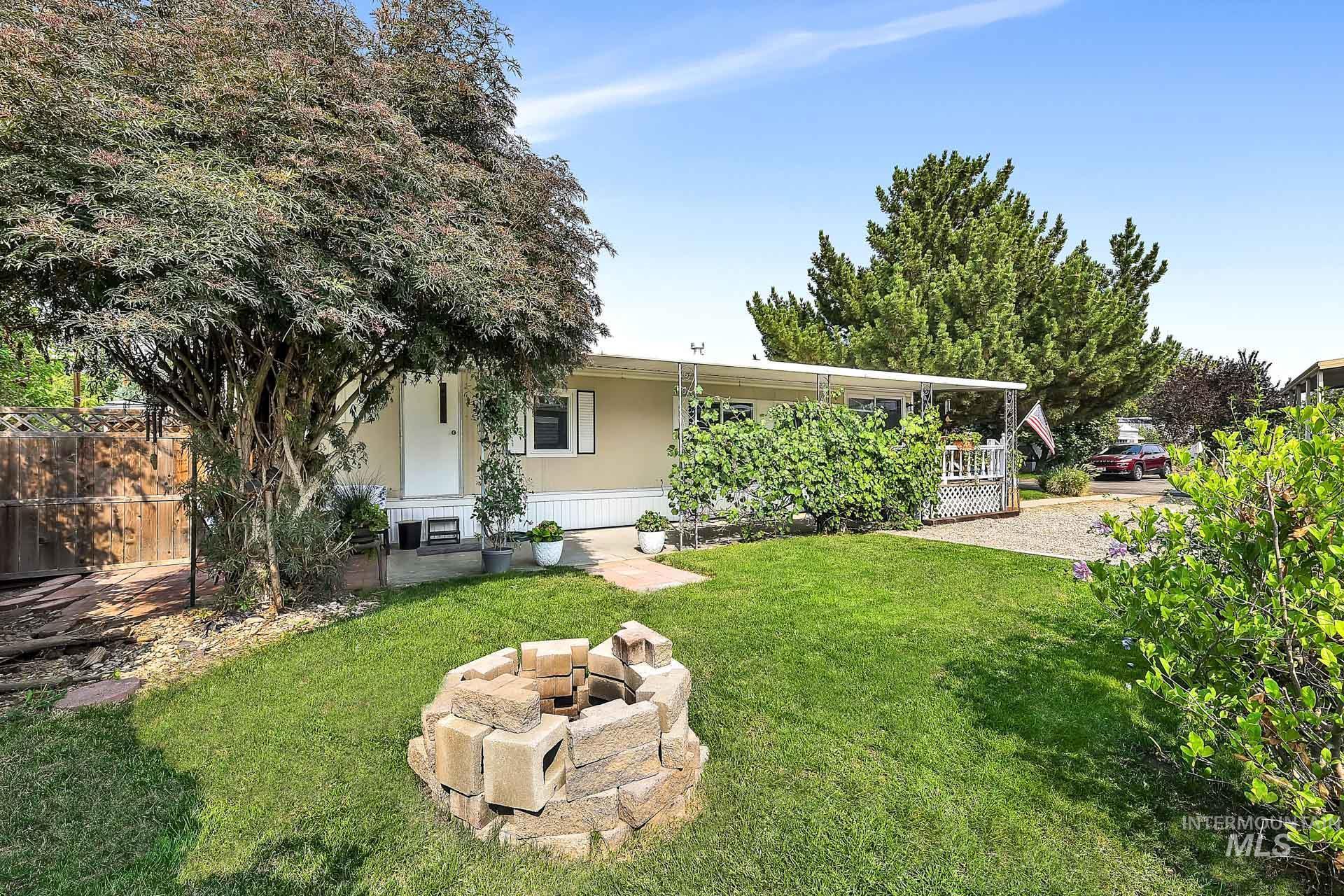 Back of property with a lawn, an outdoor fire pit, and a porch