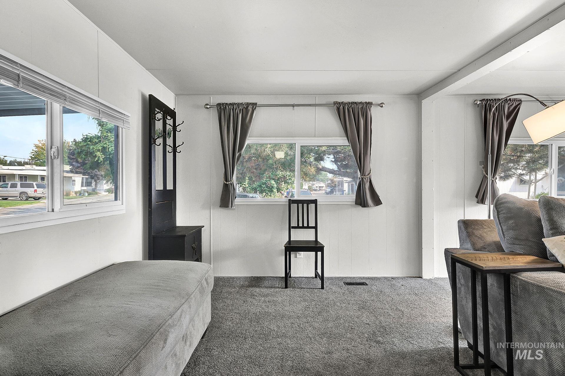 Carpeted bedroom featuring multiple windows