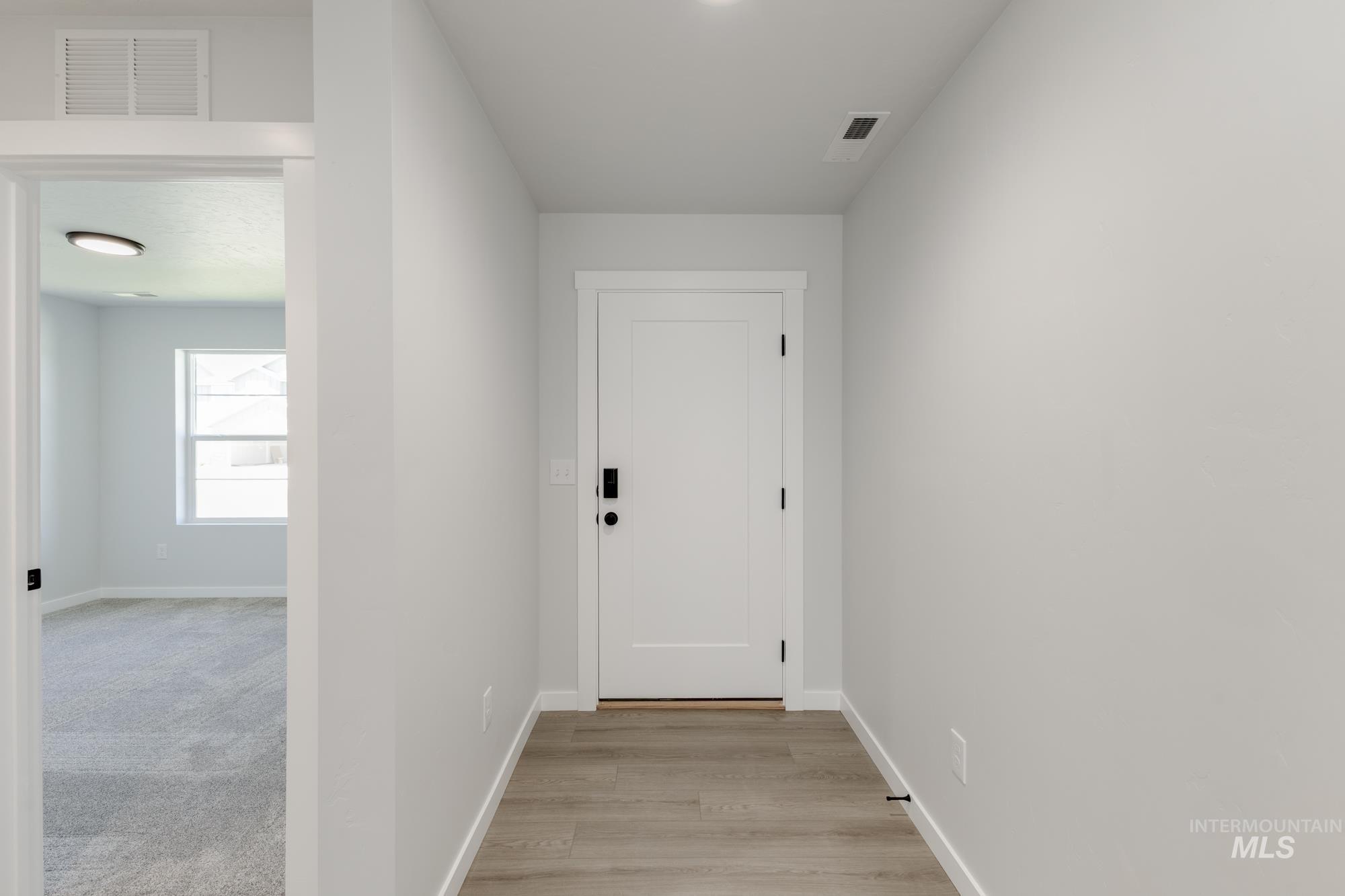 Hallway with baseboards and light wood-style flooring