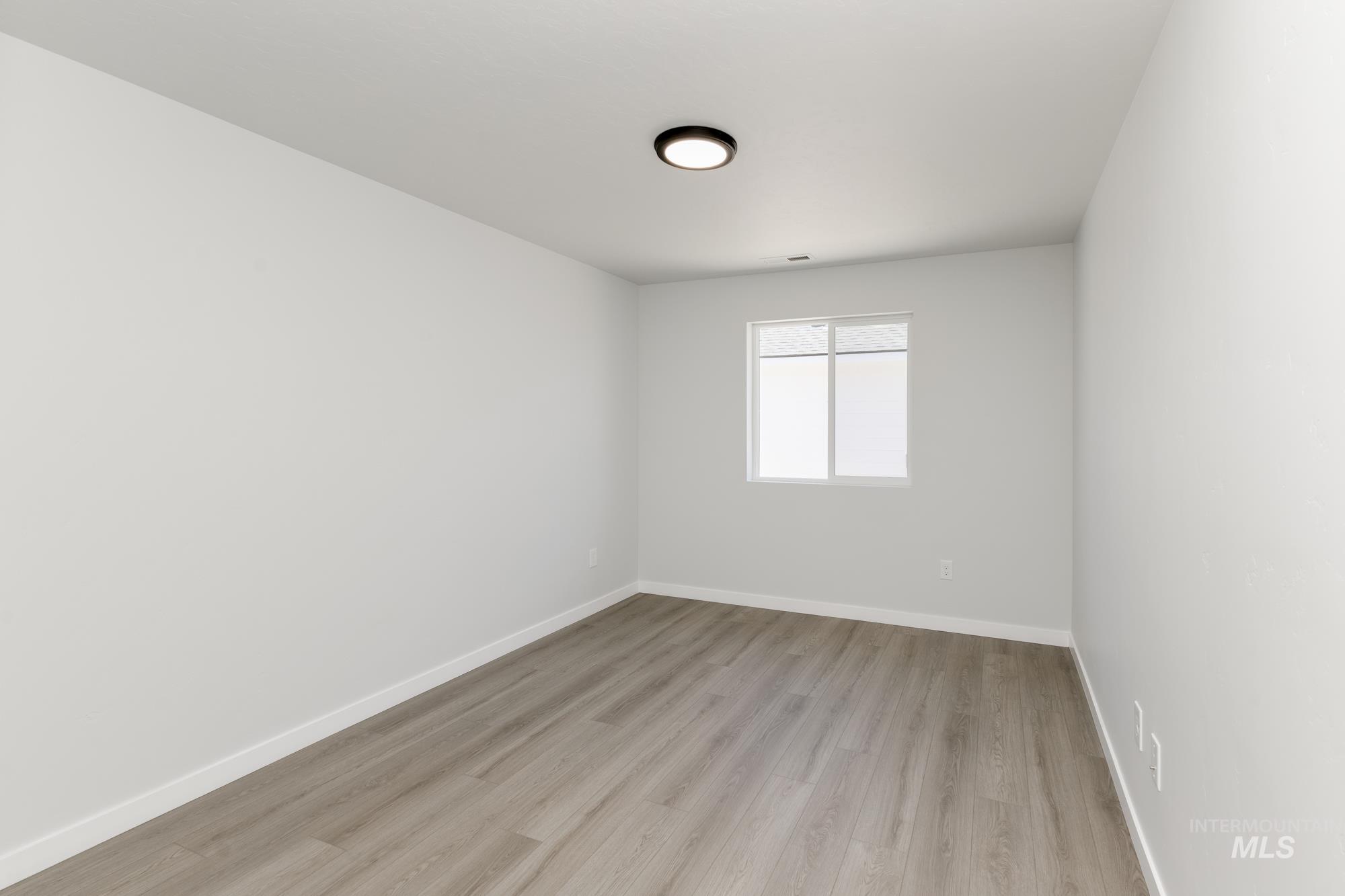 Spare room featuring baseboards and light wood finished floors