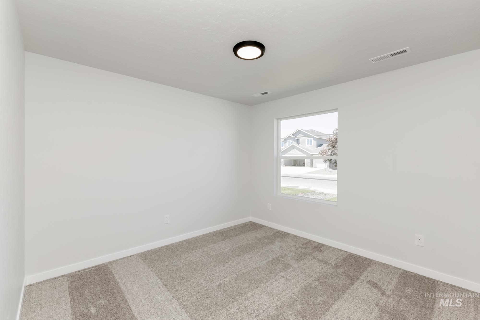 Carpeted empty room featuring baseboards