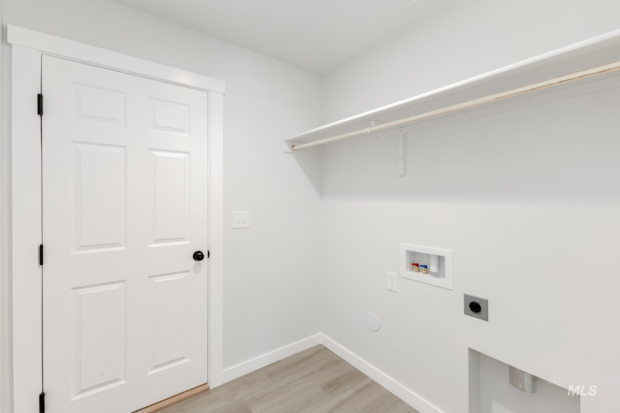 Washroom featuring hookup for an electric dryer, washer hookup, and light wood-style flooring