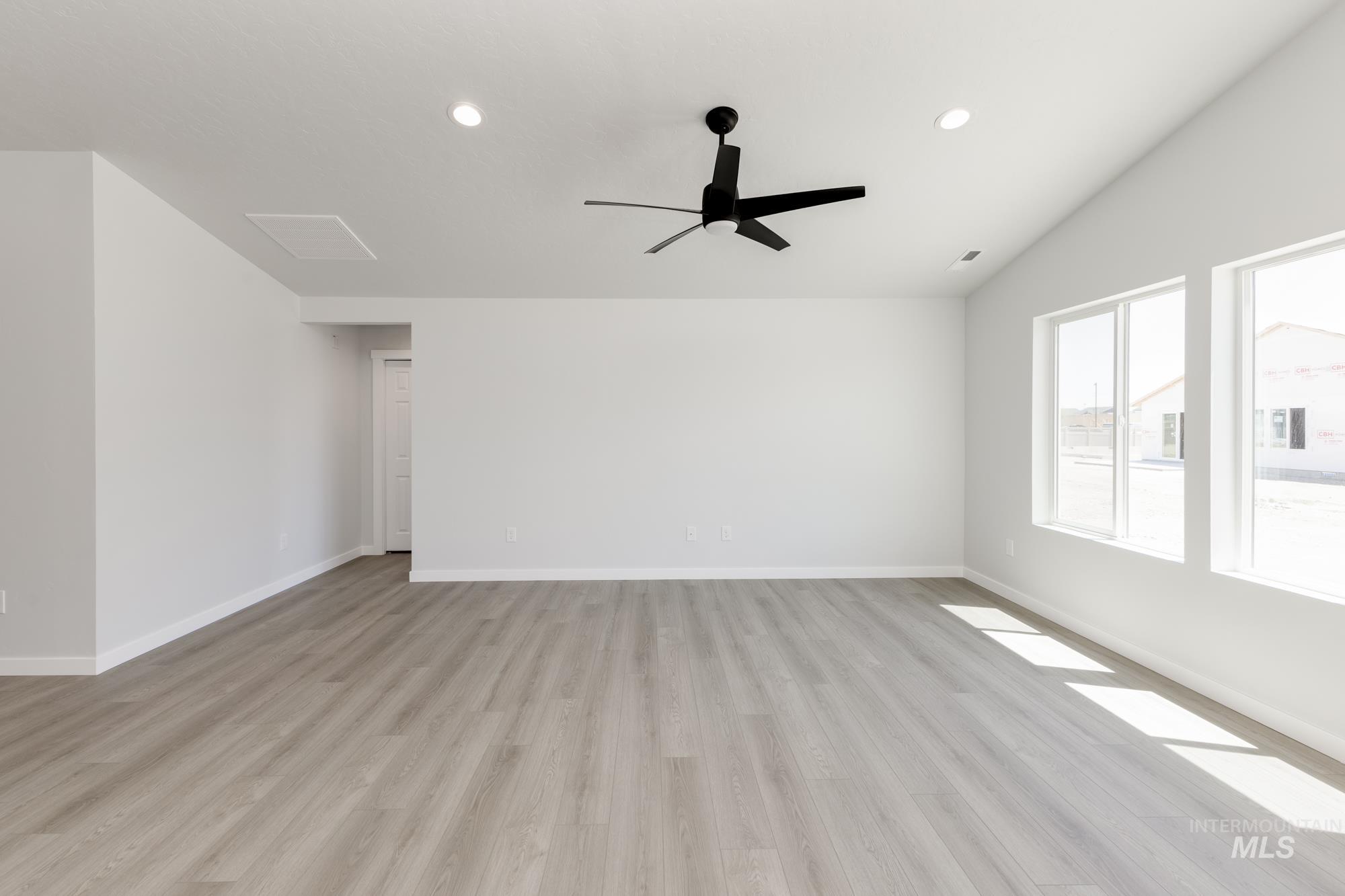 Spare room featuring light wood-style floors, lofted ceiling, ceiling fan, and recessed lighting