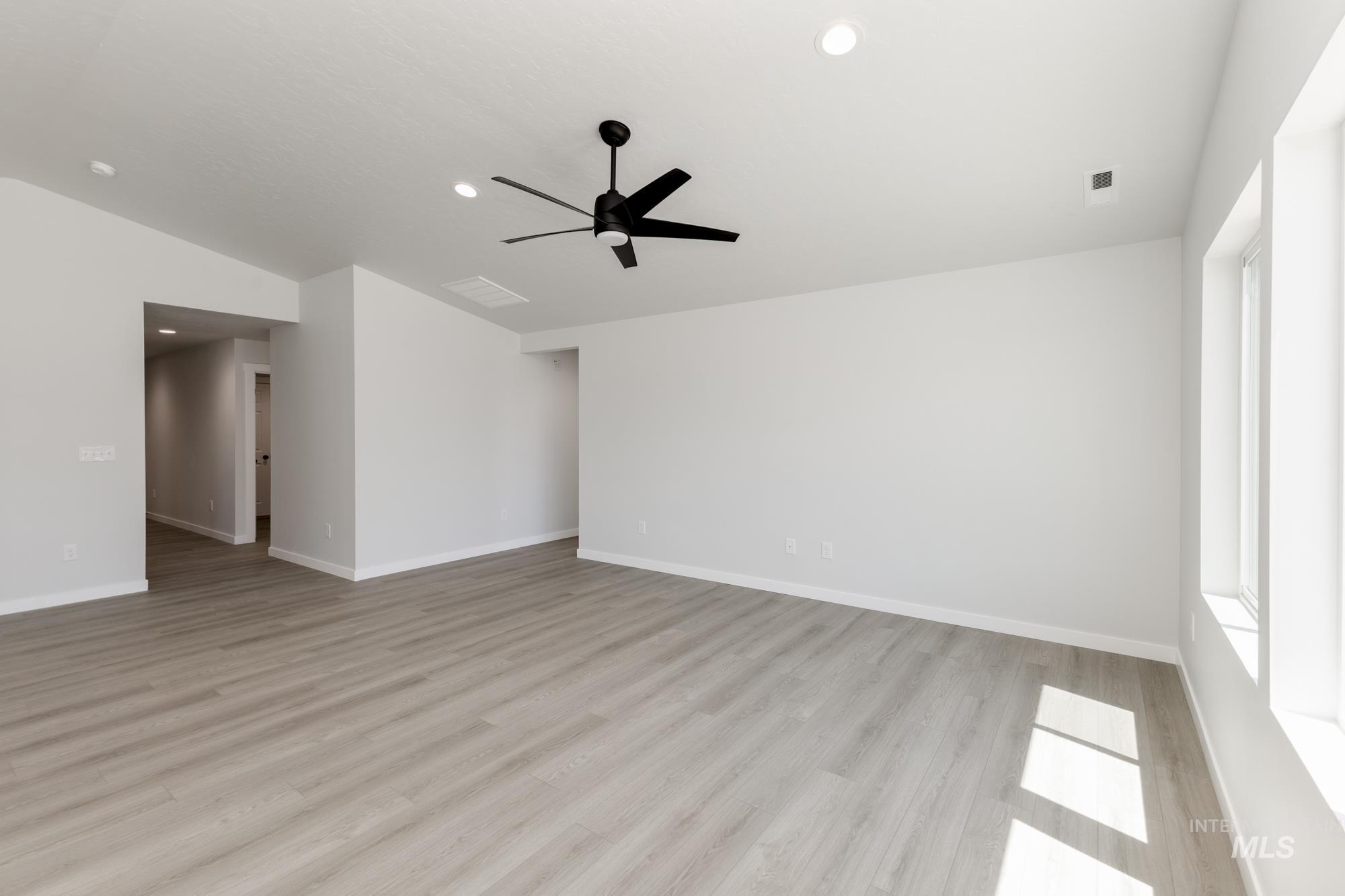 Empty room featuring lofted ceiling, light wood-style flooring, ceiling fan, and recessed lighting