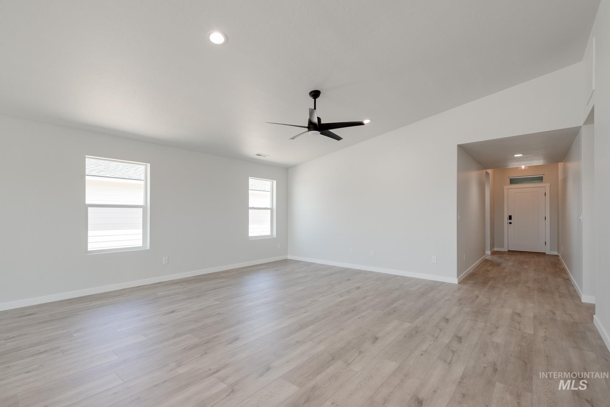 Empty room featuring ceiling fan, light wood-style flooring, and recessed lighting