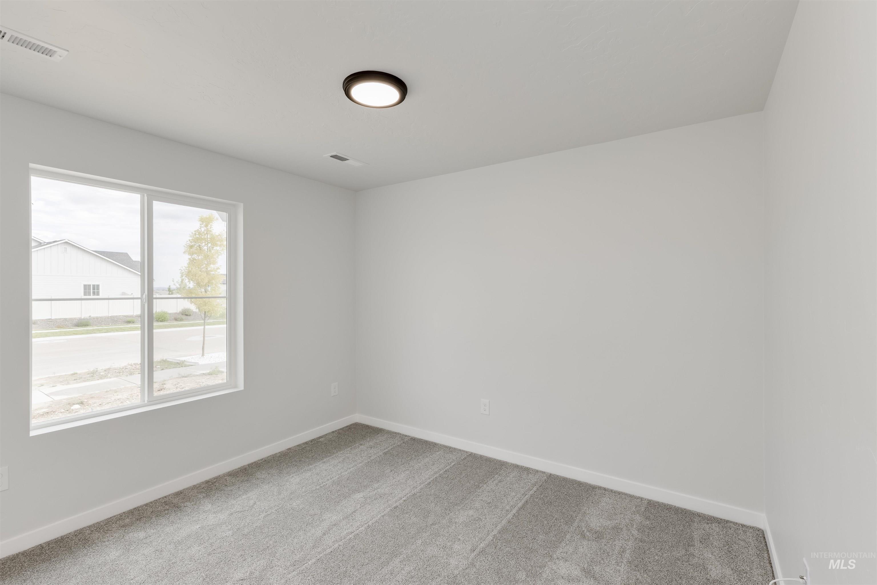 Carpeted empty room with baseboards
