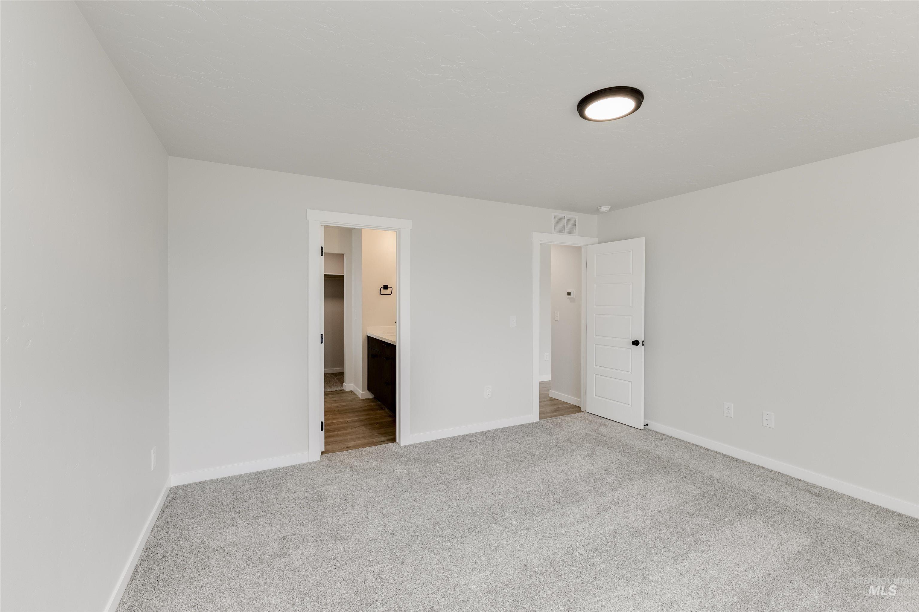 Unfurnished bedroom with carpet flooring and connected bathroom