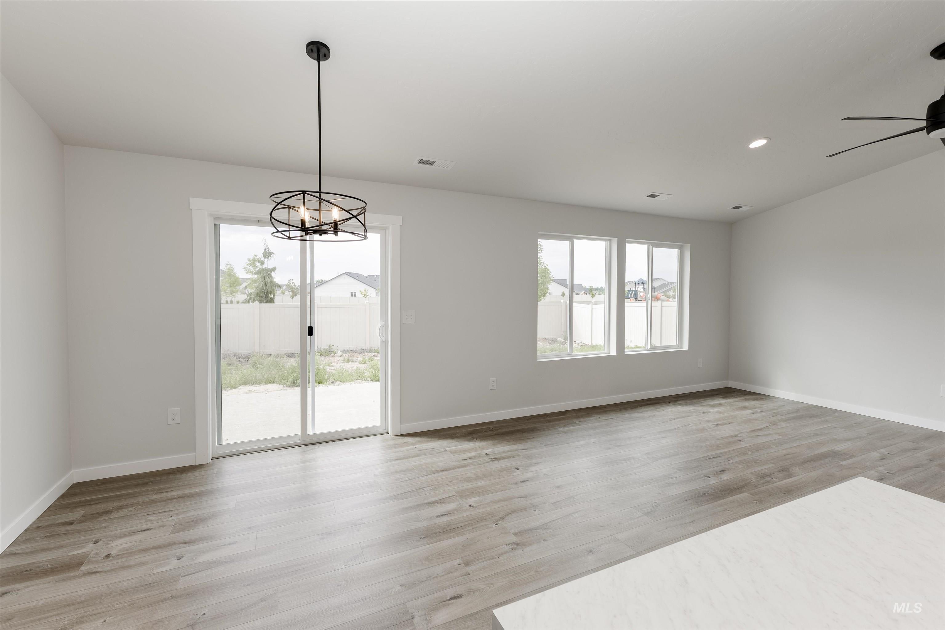 Unfurnished dining area featuring light wood finished floors, a chandelier, and recessed lighting