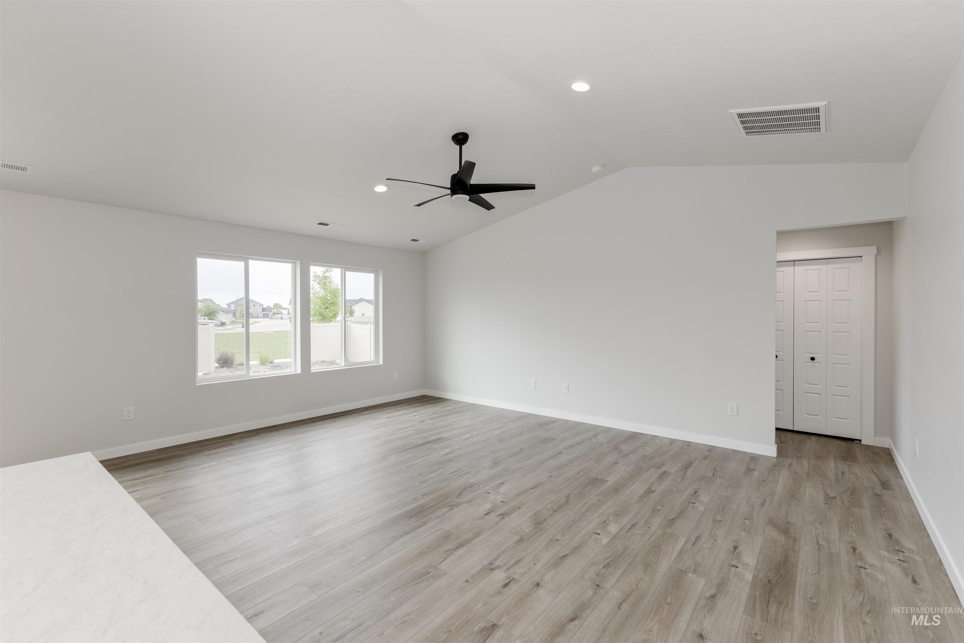 Unfurnished living room featuring light wood-type flooring, vaulted ceiling, recessed lighting, and a ceiling fan