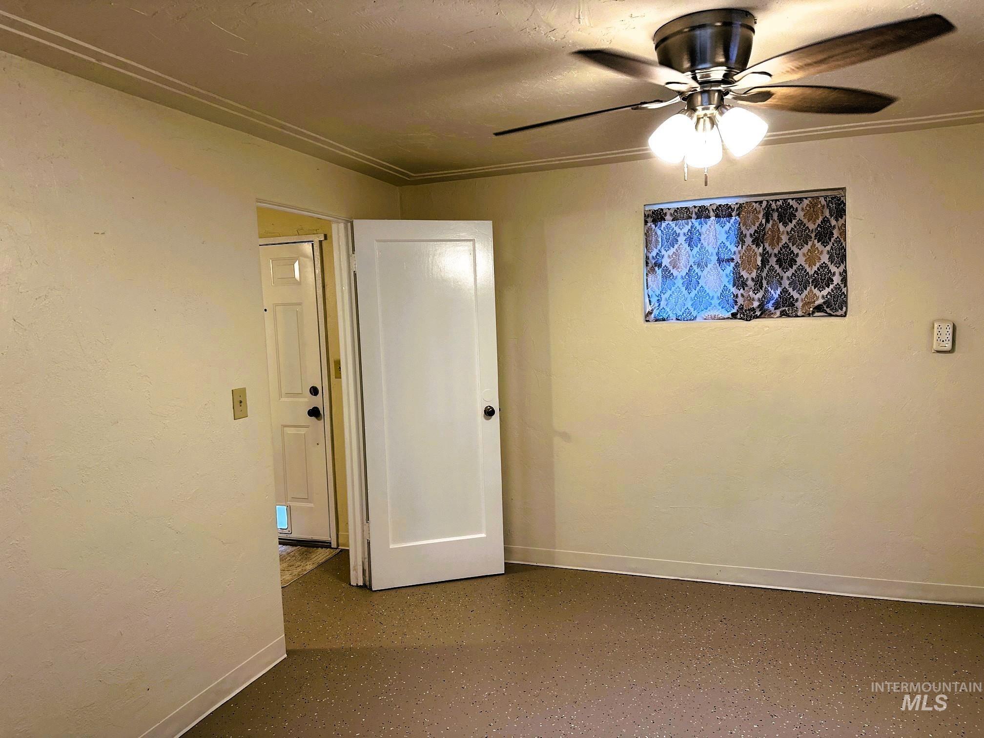 Unfurnished room with baseboards and a ceiling fan