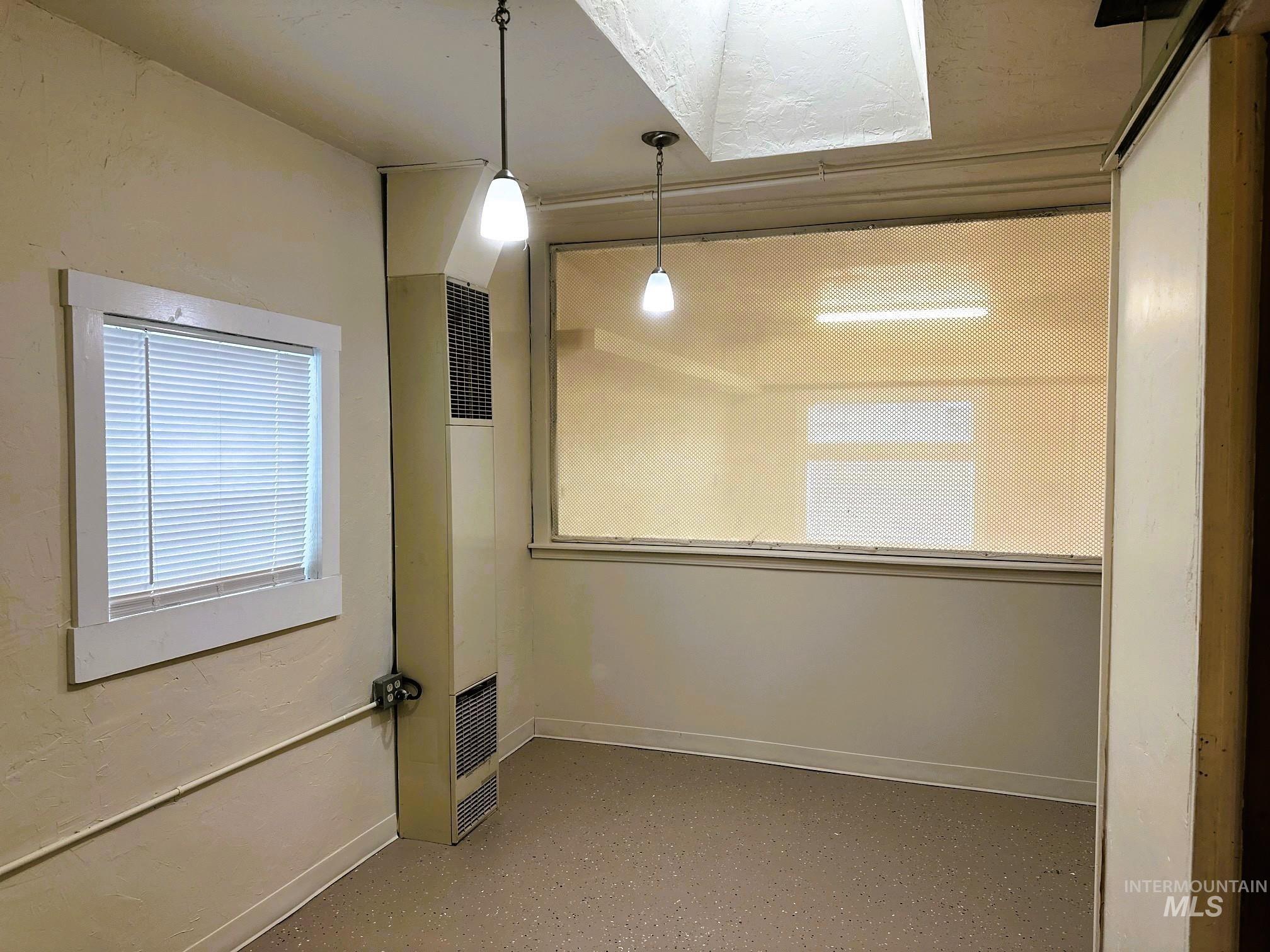 Empty room featuring plenty of natural light and a heating unit