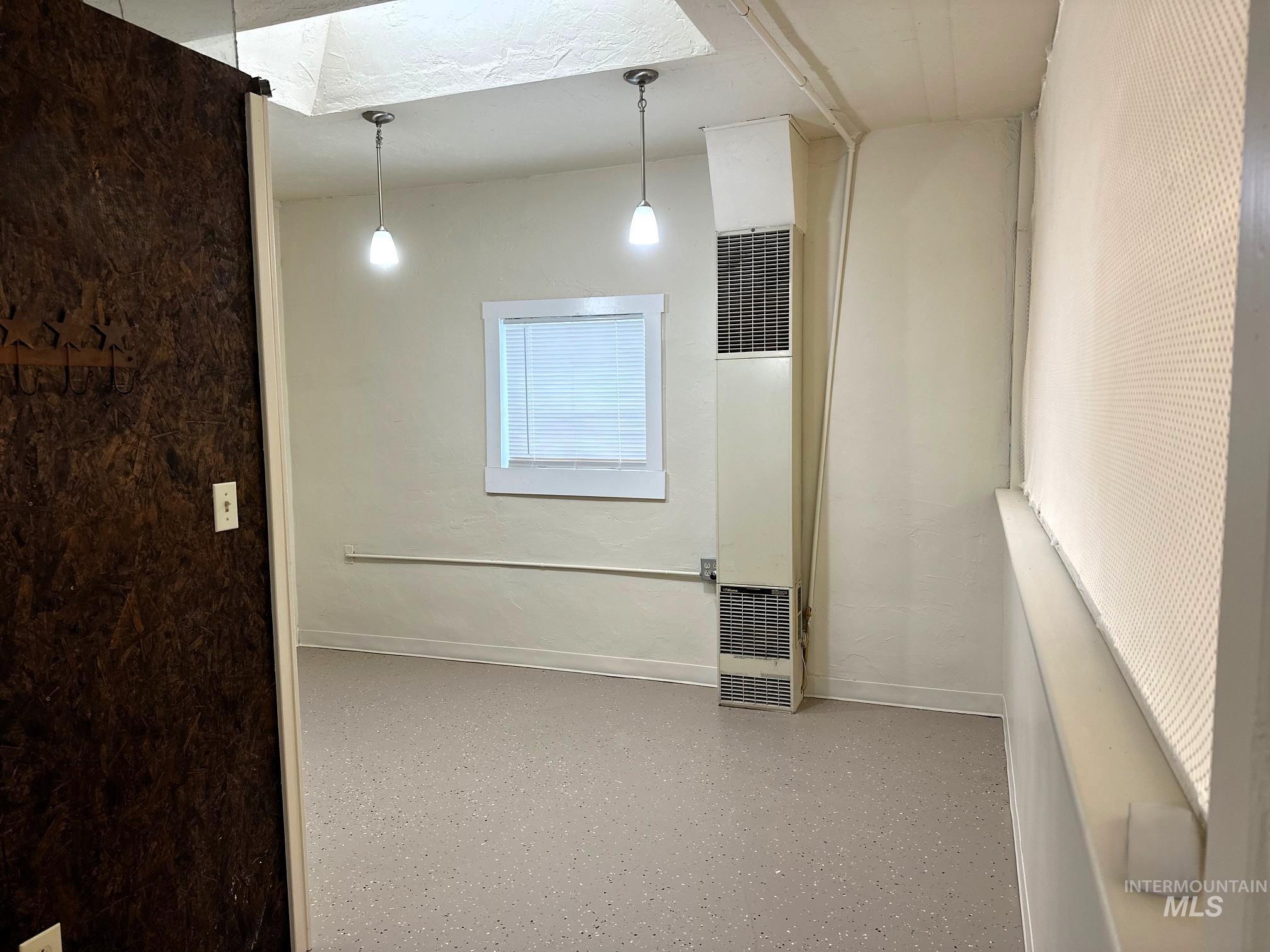 Empty room featuring a heating unit and baseboards
