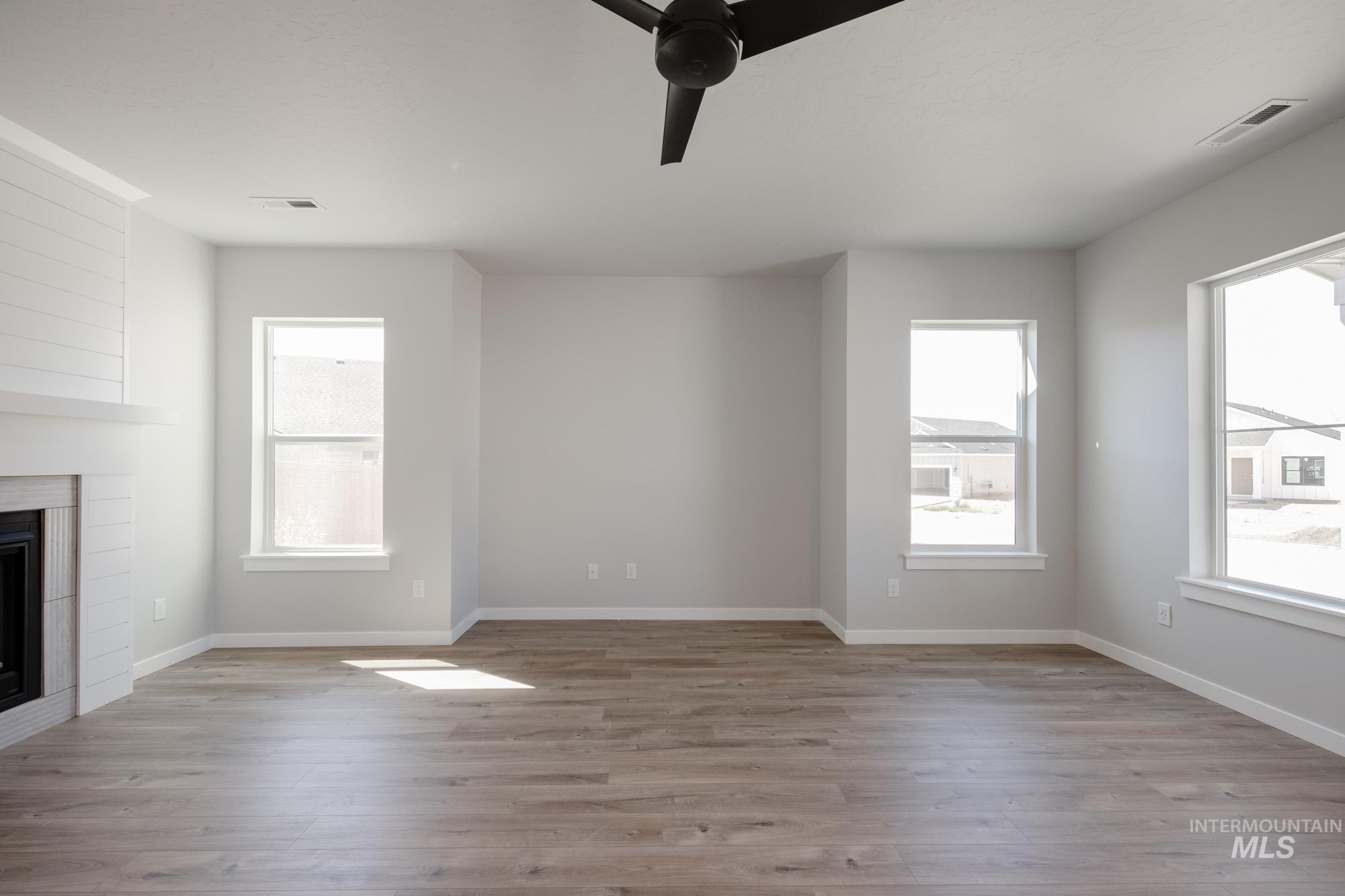 Unfurnished living room with light wood-type flooring and healthy amount of natural light