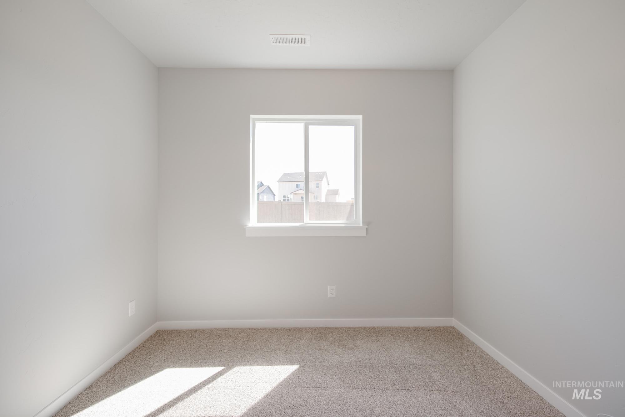 Spare room featuring light colored carpet and baseboards