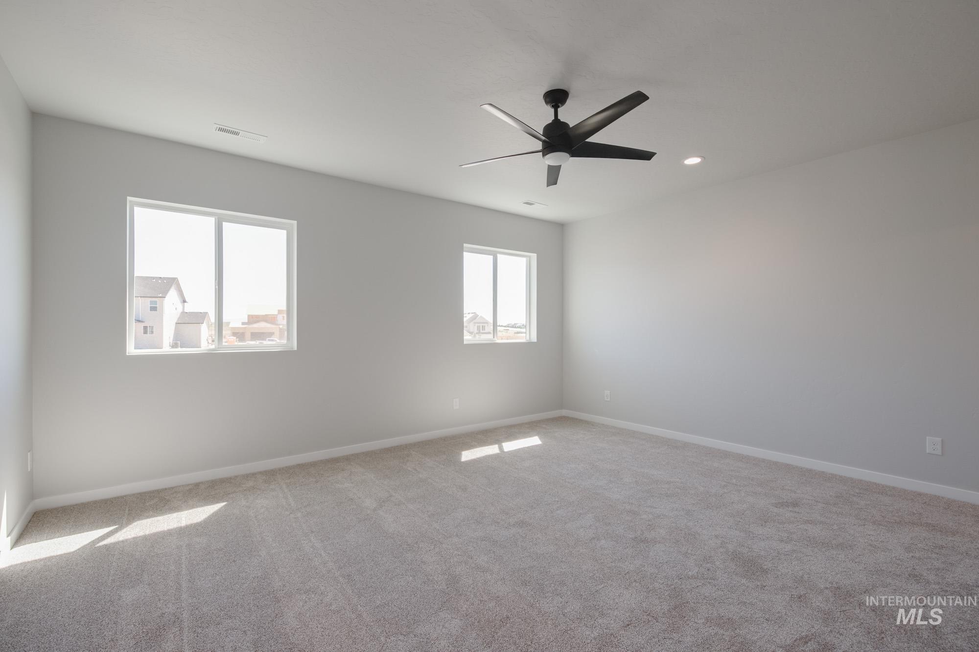 Unfurnished room featuring light carpet, a ceiling fan, and recessed lighting
