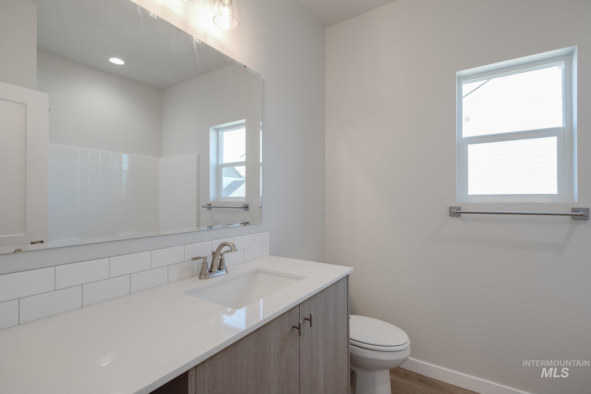 Half bathroom featuring vanity and light wood-style flooring