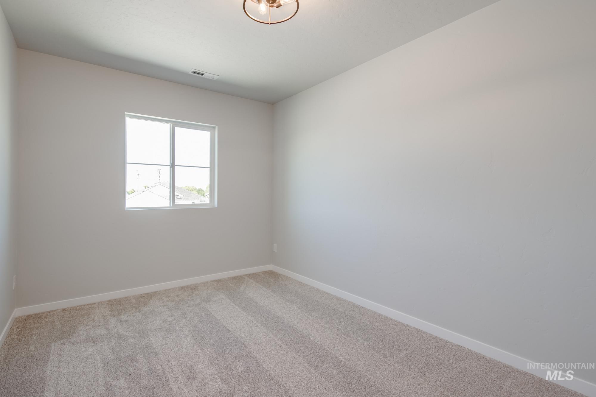 Carpeted empty room featuring baseboards