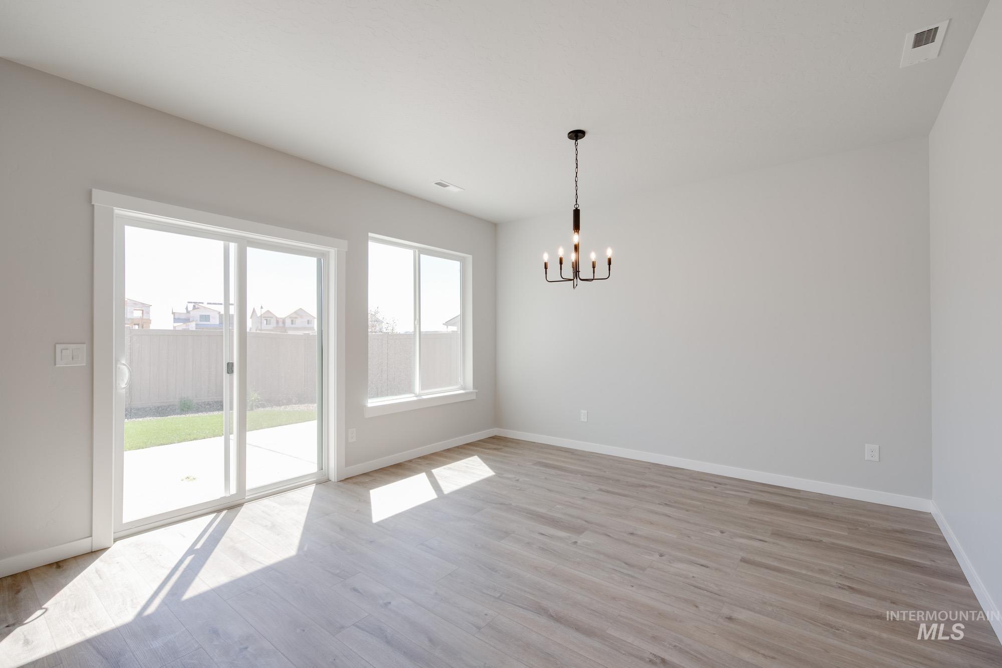 Unfurnished dining area with light wood finished floors and a chandelier