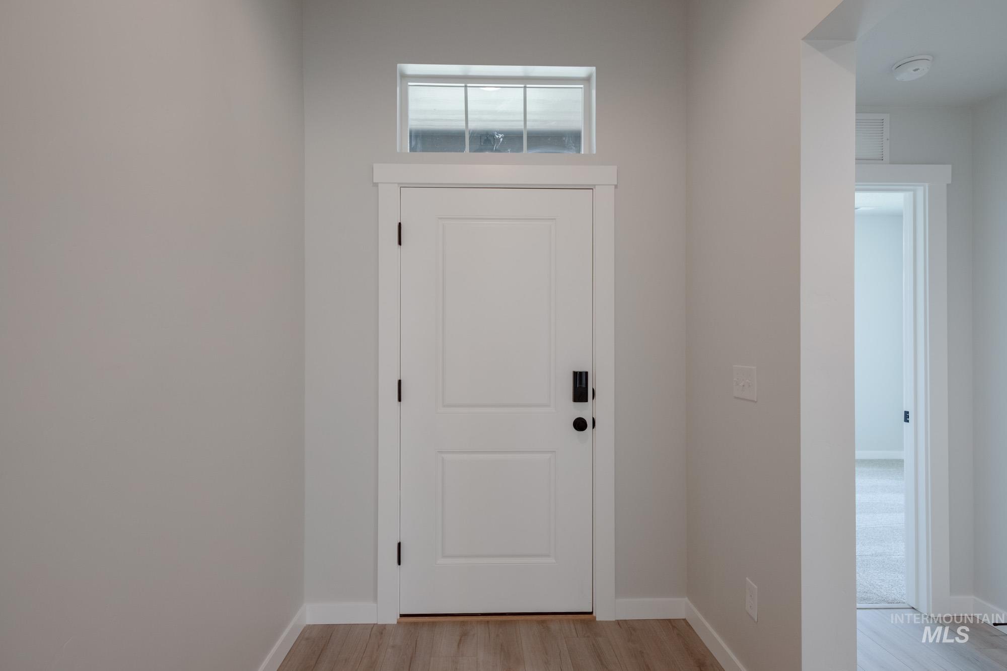 Entryway featuring baseboards and light wood finished floors