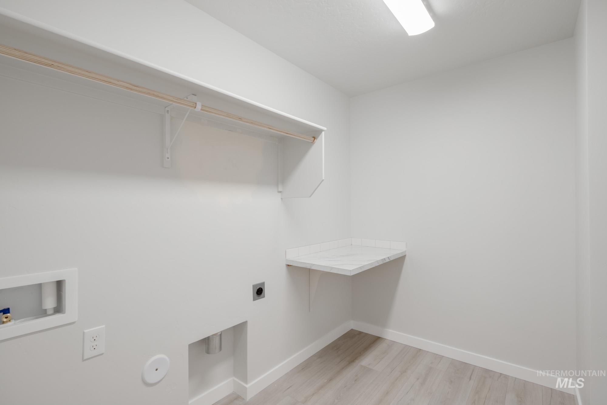 Washroom with light wood finished floors, electric dryer hookup, and washer hookup