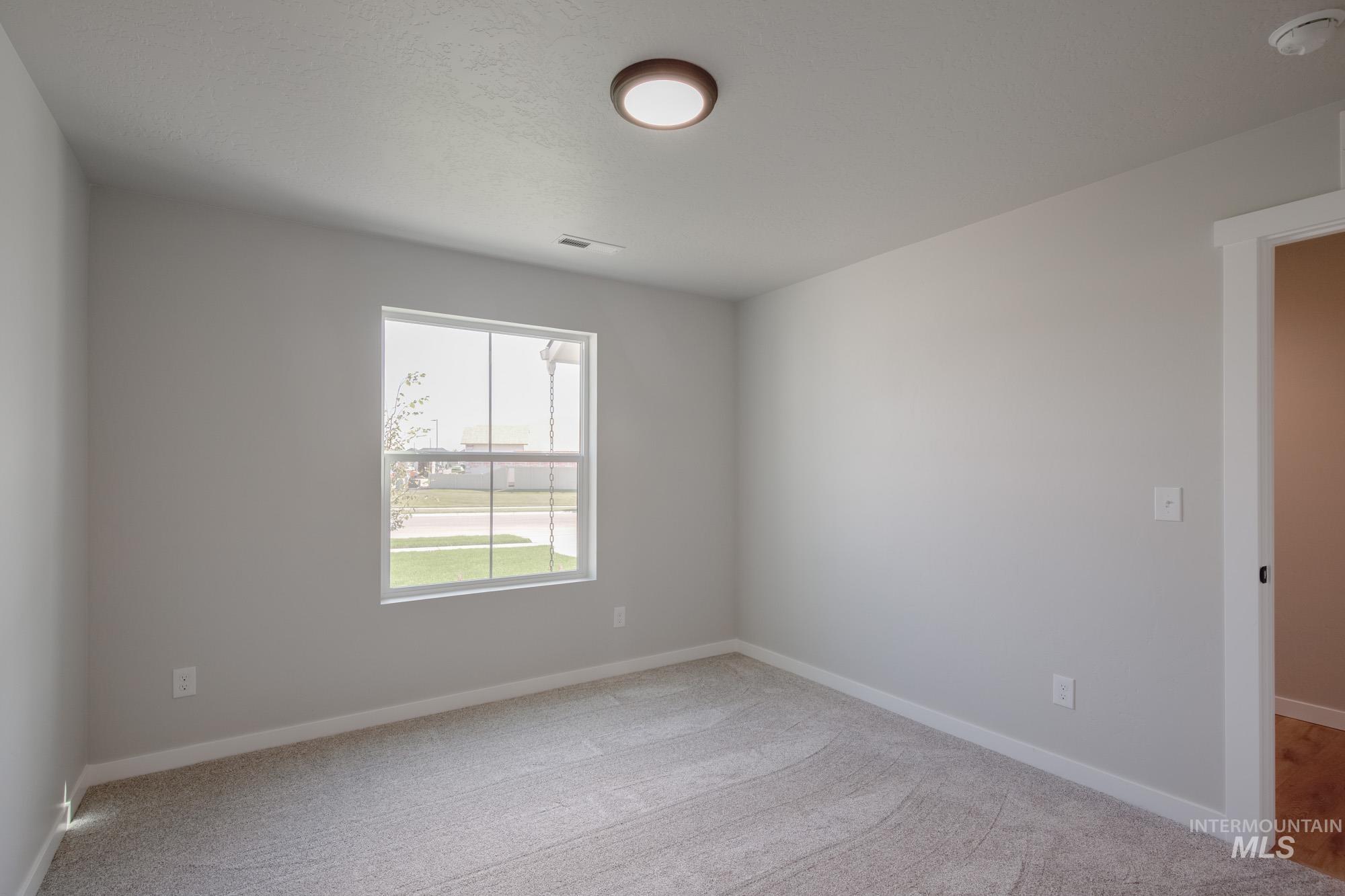 Spare room featuring baseboards and light colored carpet