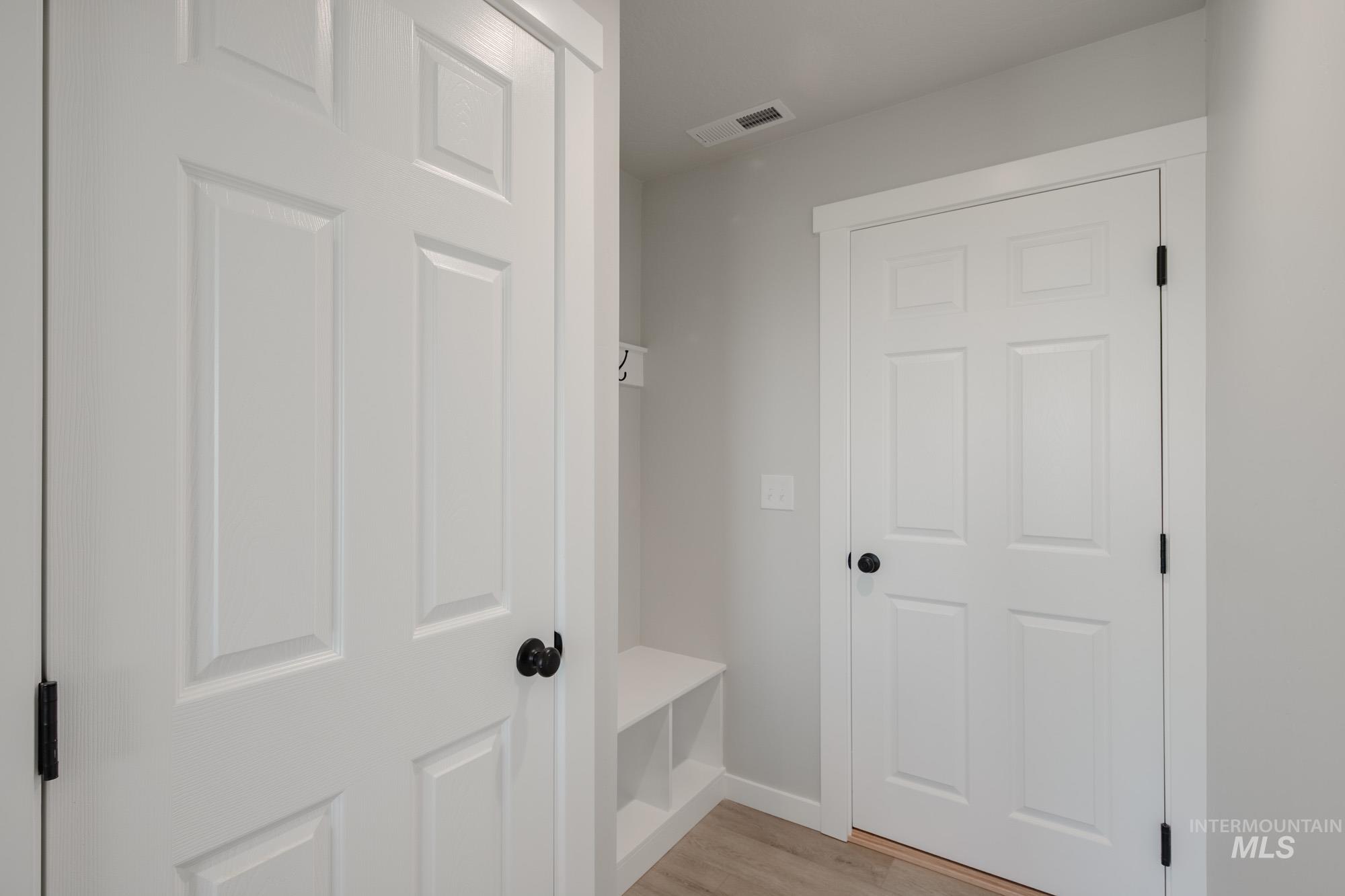 Mudroom with light wood finished floors and baseboards