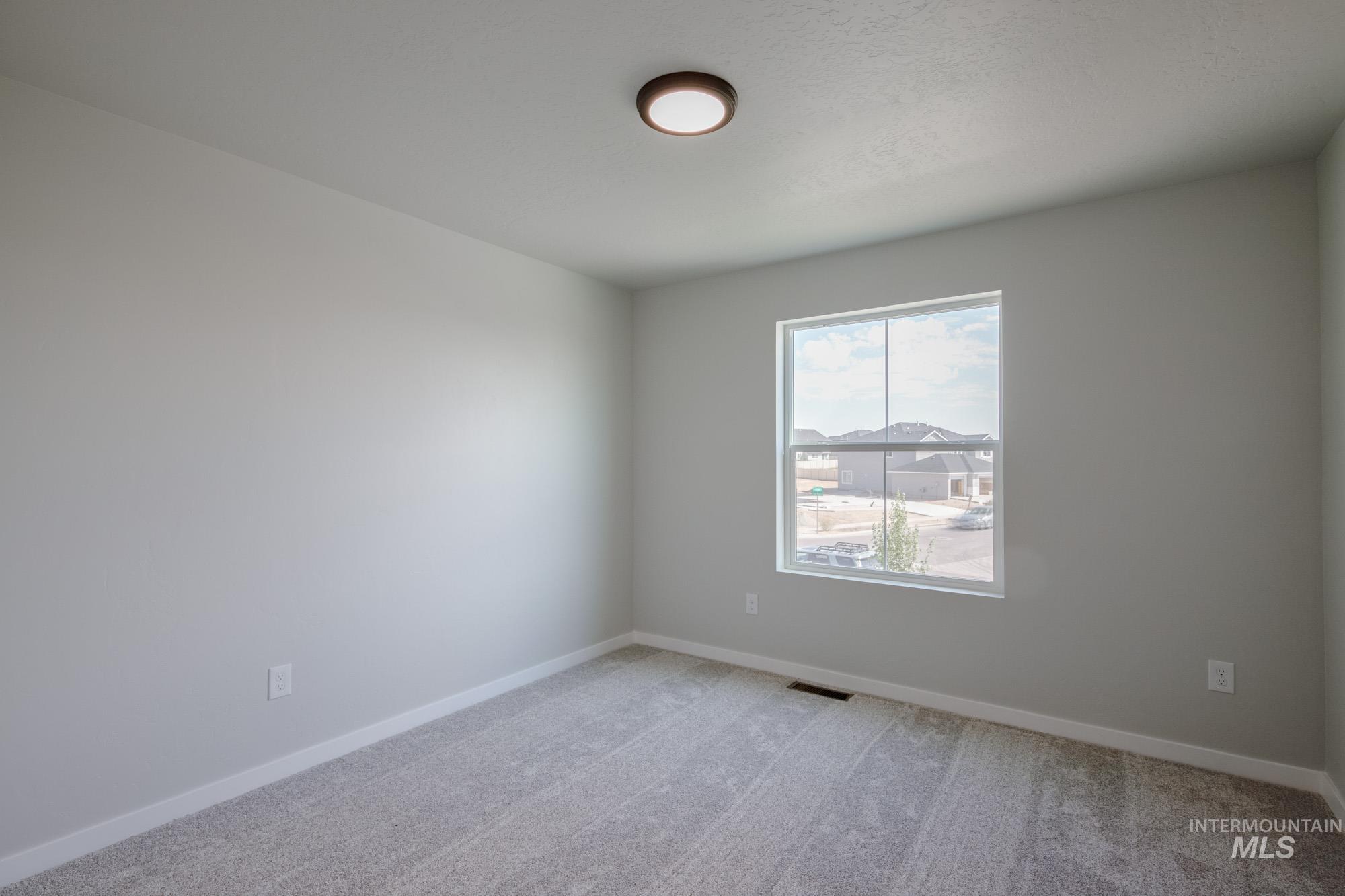 Empty room featuring light carpet and baseboards