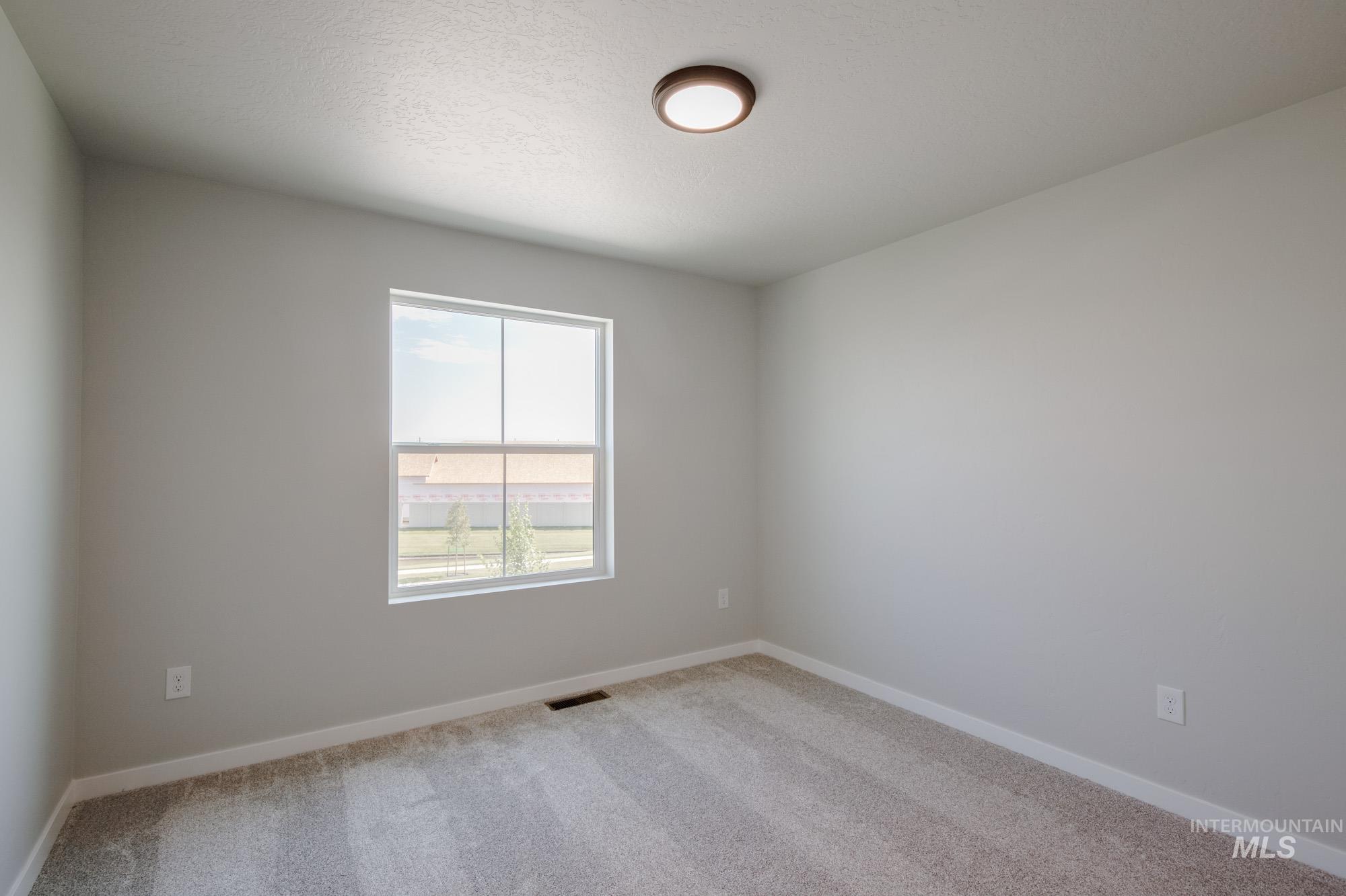 Spare room with carpet flooring and a textured ceiling