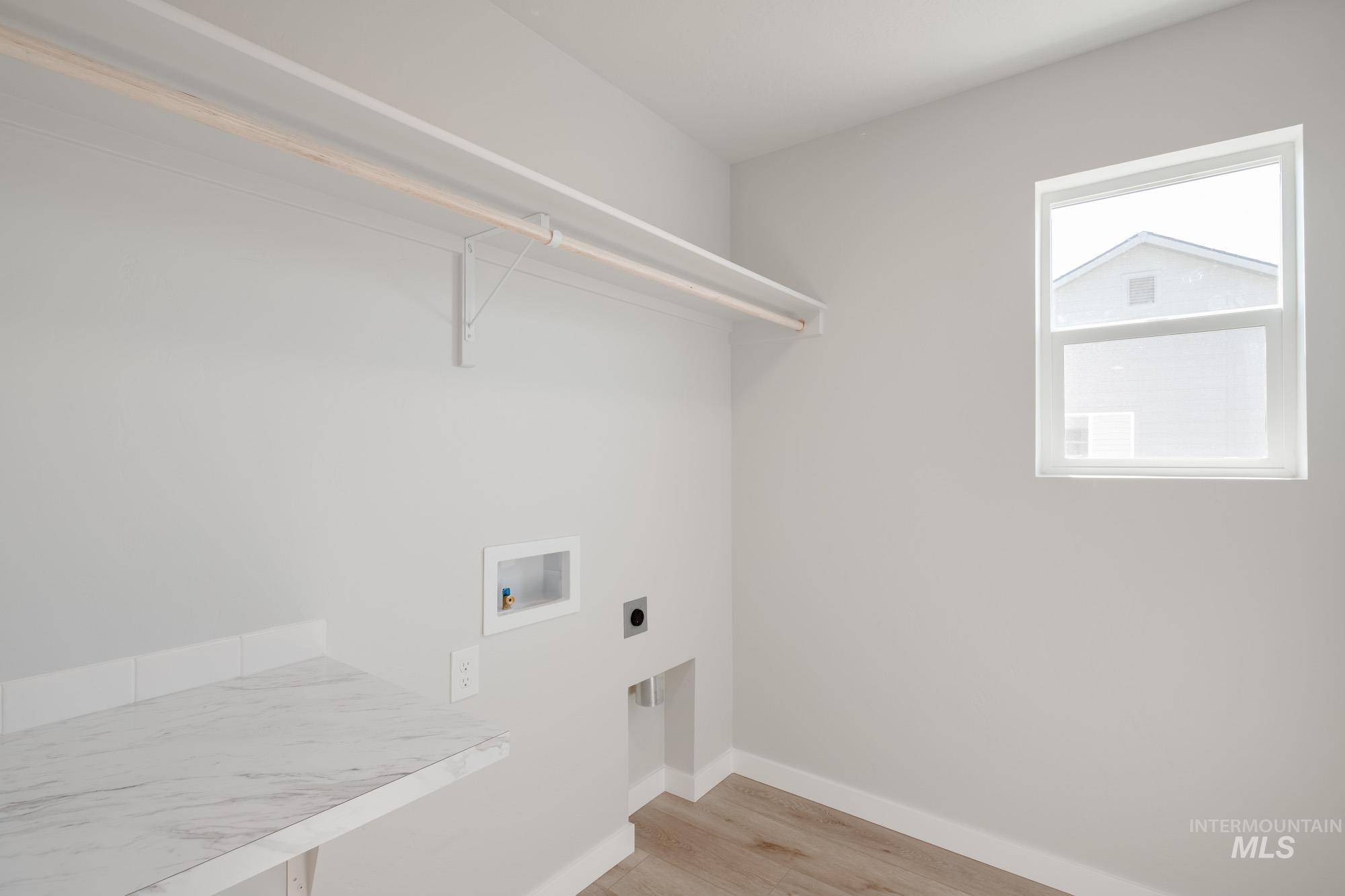 Washroom featuring light wood-type flooring, washer hookup, and electric dryer hookup