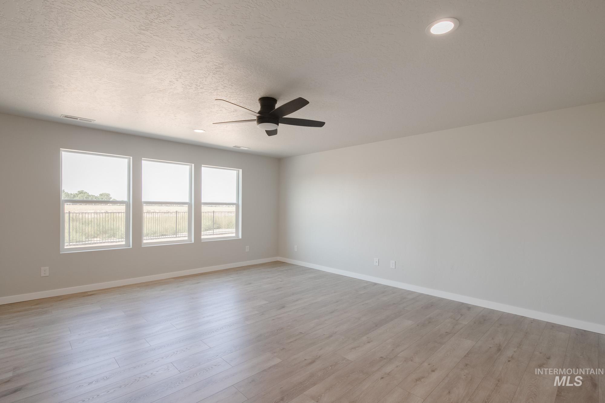 Empty room featuring light wood finished floors, a textured ceiling, recessed lighting, and ceiling fan
